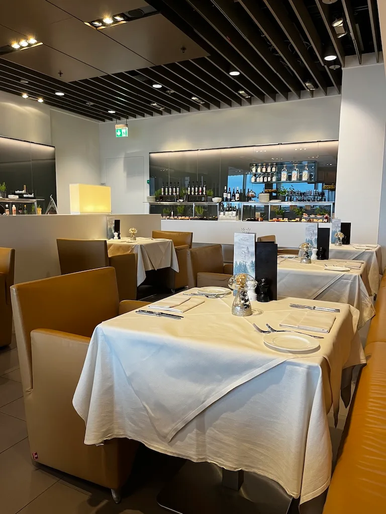 Gepflegter First Class Lounge mit Tischen und Stühlen