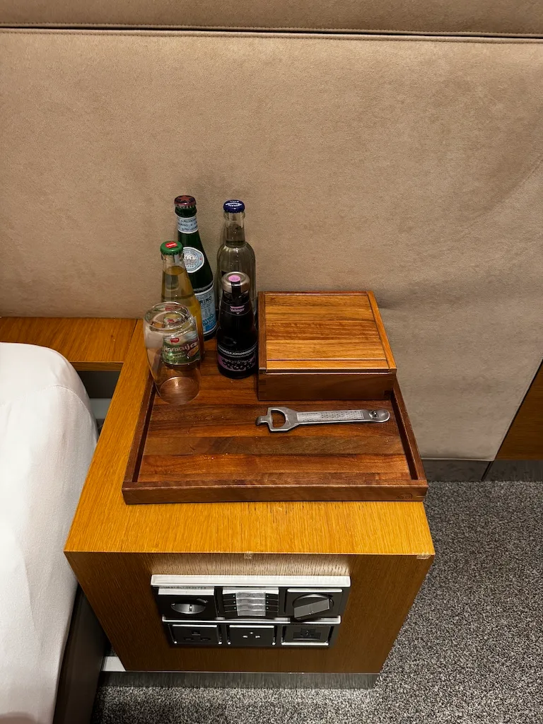 Holztablett mit Flaschen und Zangen auf Nachttisch