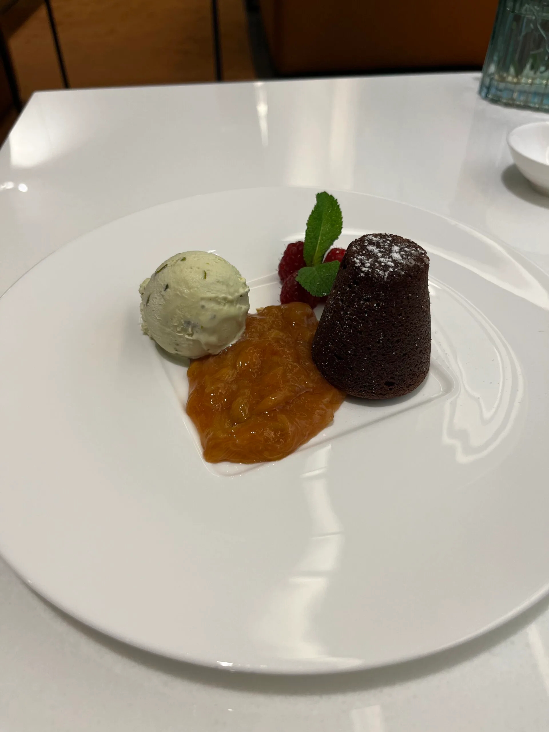 Kuchen mit Eiscreme, Marmelade und Himbeeren auf weißem Teller
