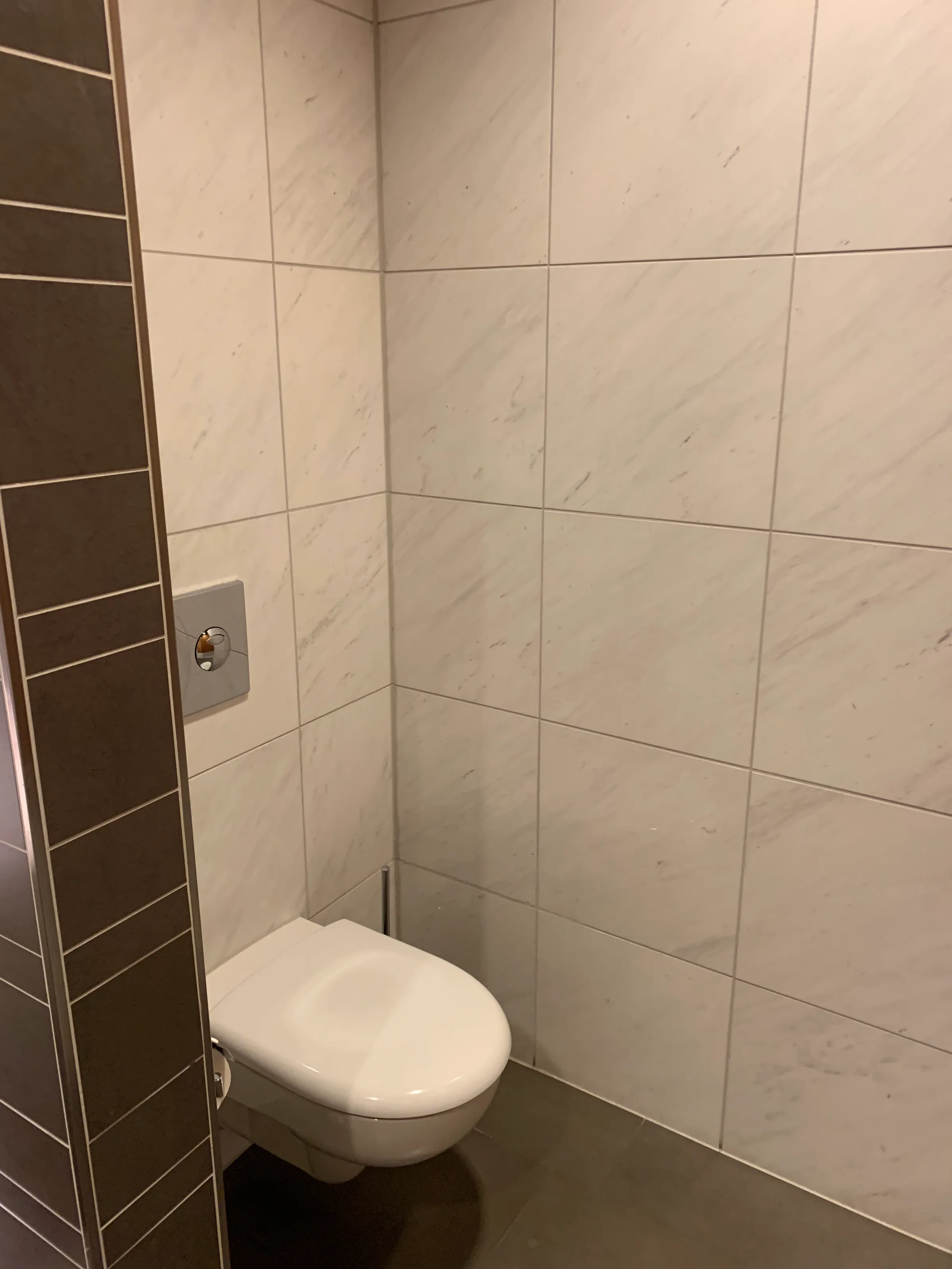 kleine Toilette mit Fliesenwand