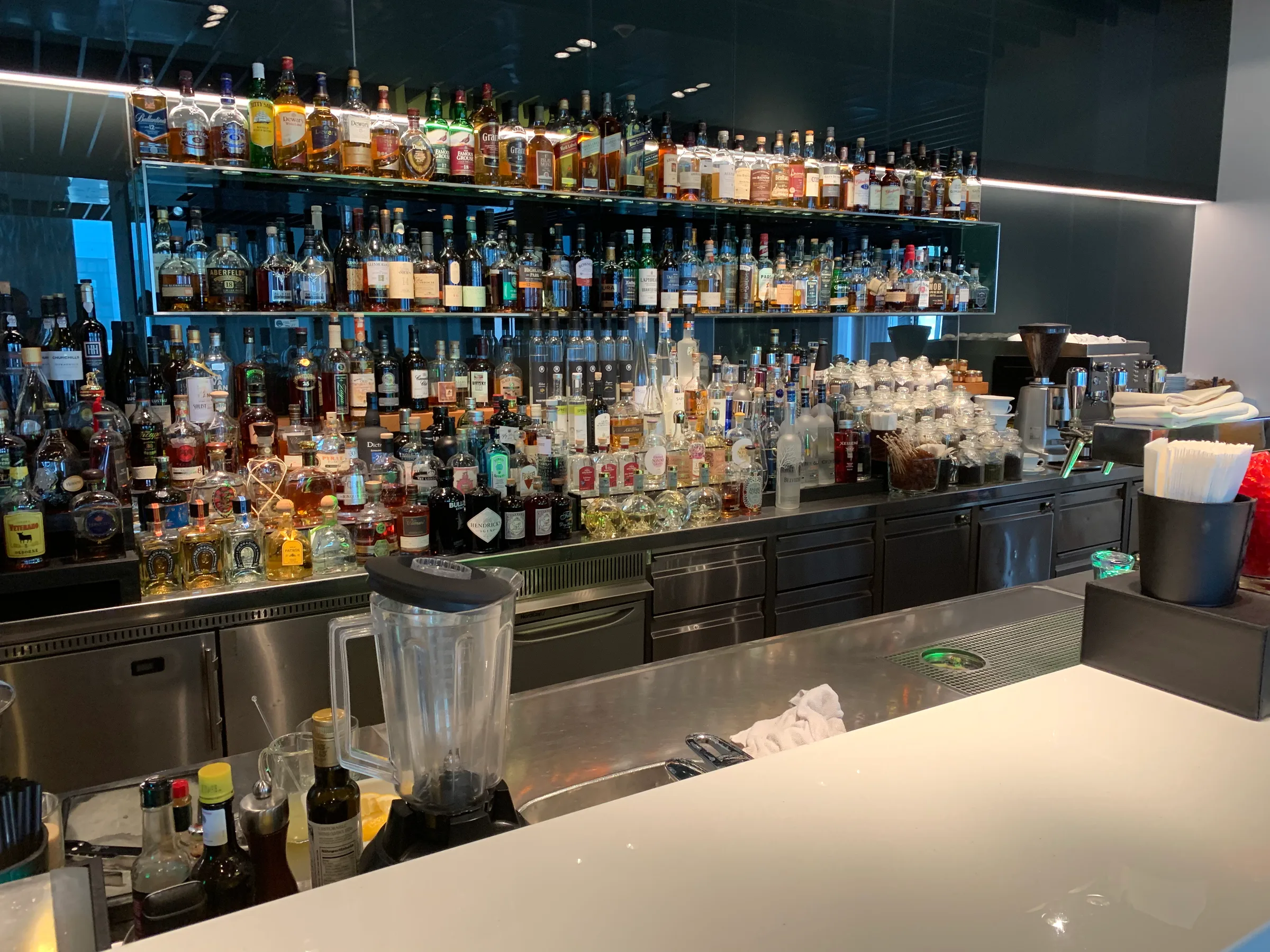 Bar mit vielen Flaschen alkoholischer Getränke und Küchenutensilien