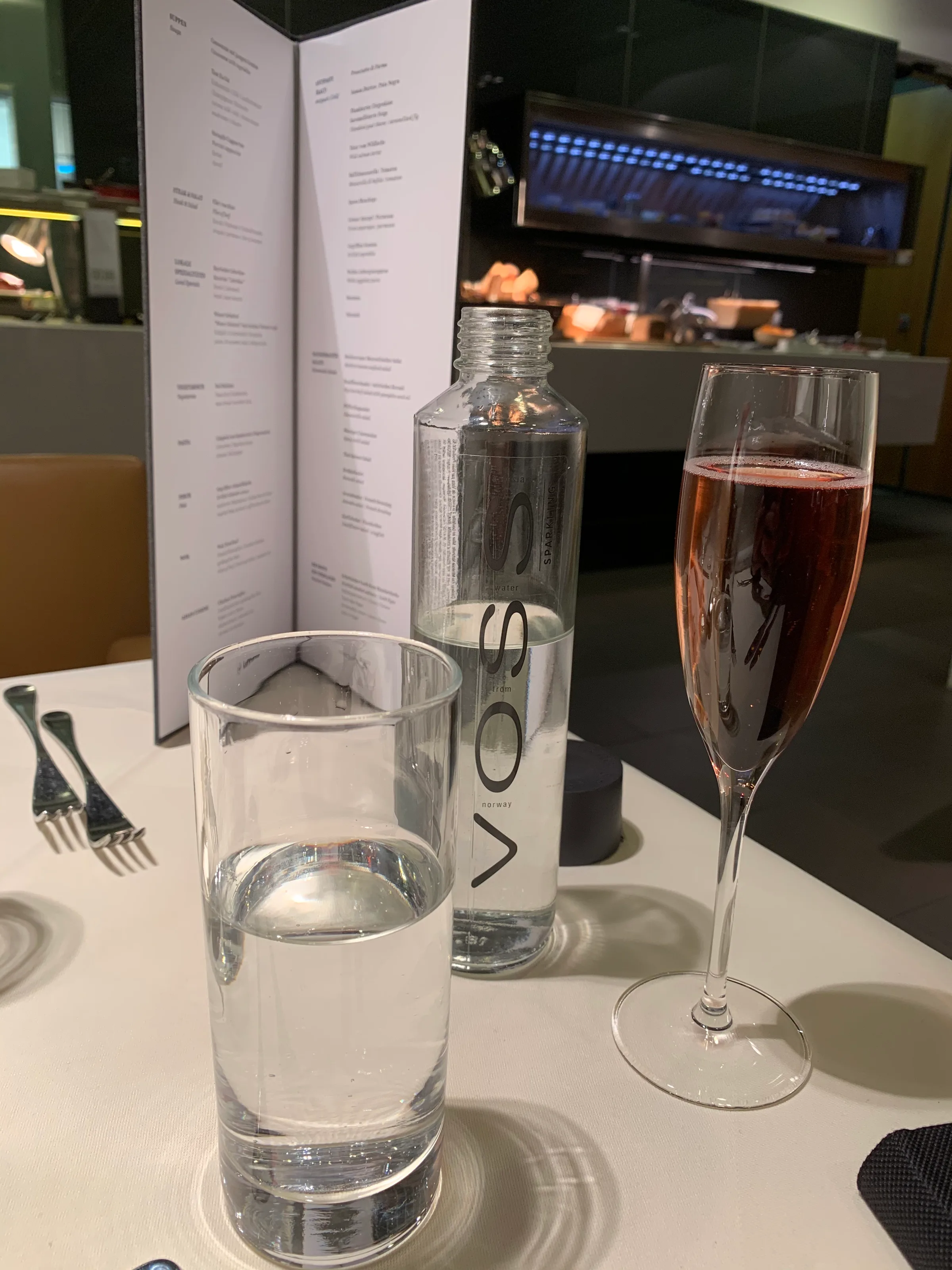 Flasche Wasser und Champagnerglas auf Tisch im Flughafenlounge