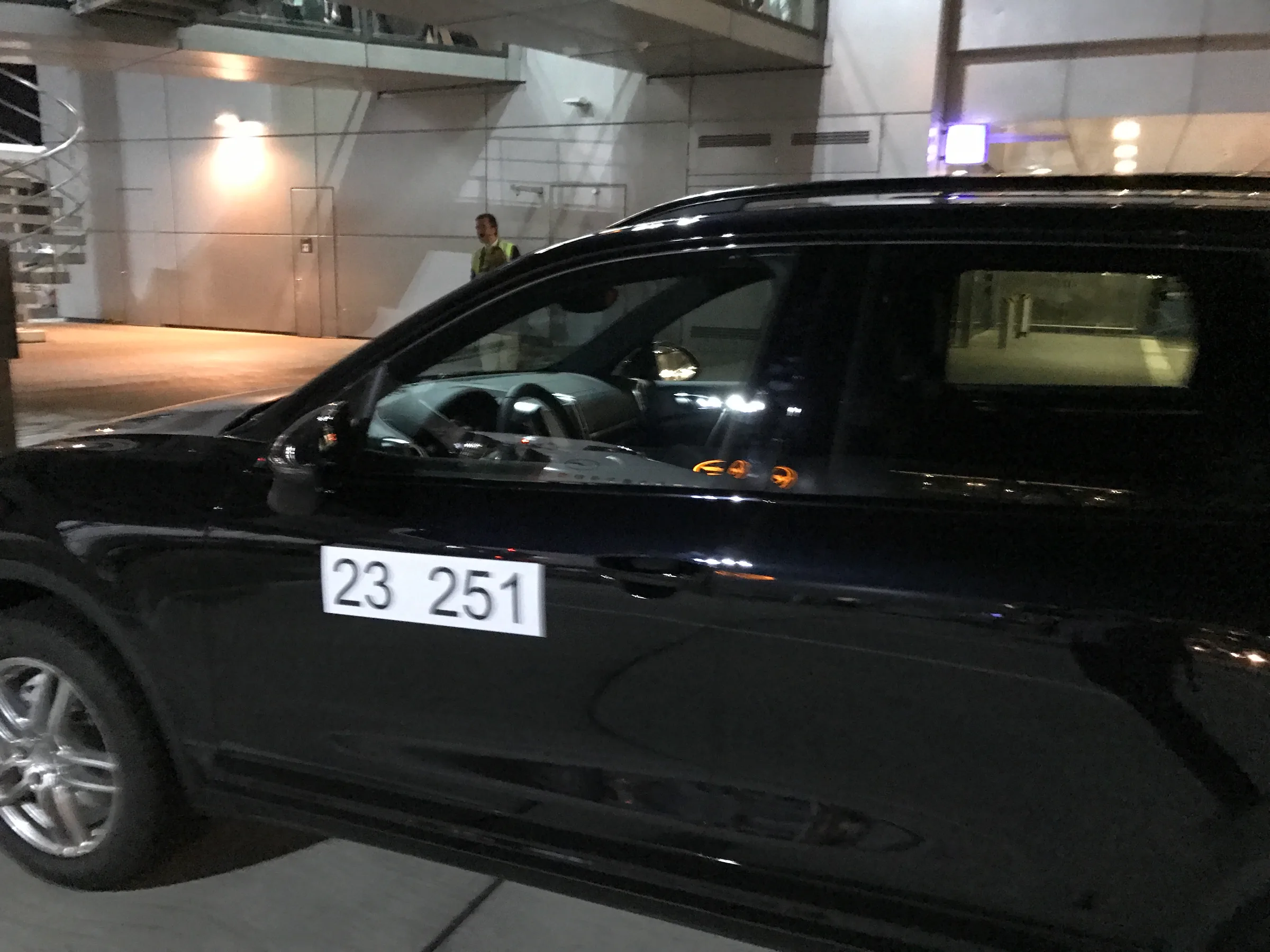 Schwarzer SUV mit Nummernschild 23 251 im Flughafenlounge