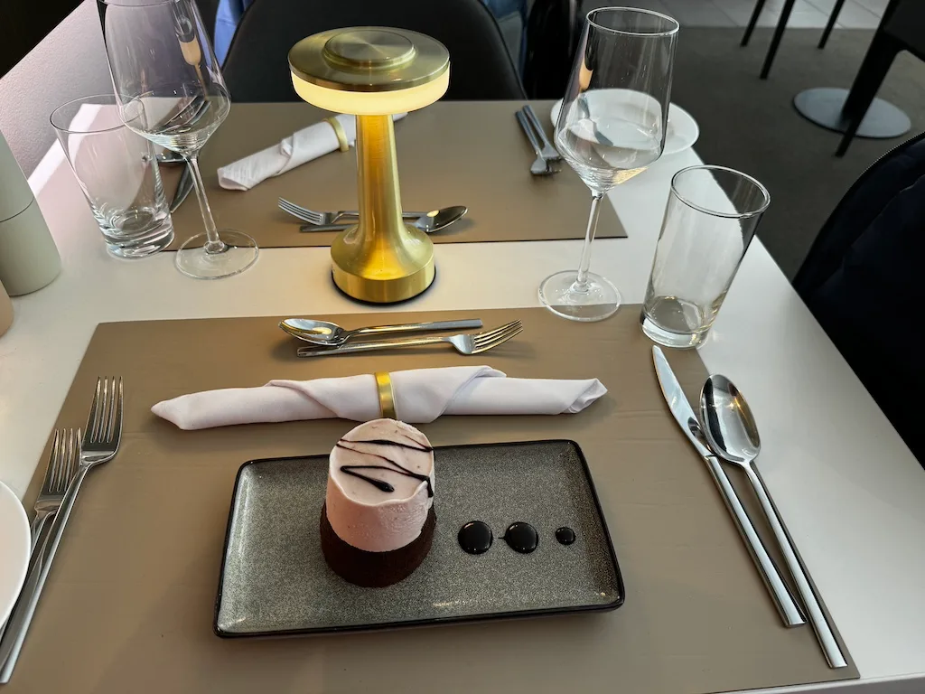 Tisch im Lufthansa First Class Lounge mit Dessert und Besteck