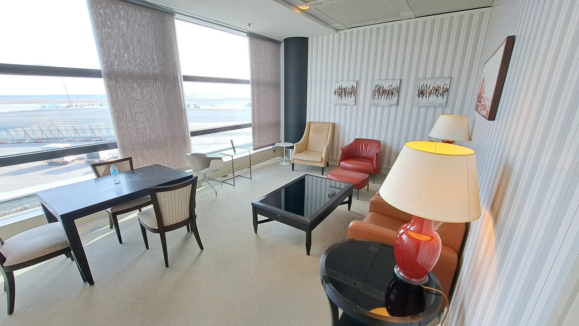 Panoramalounge mit Sitzmöbeln und Blick auf Flughafen