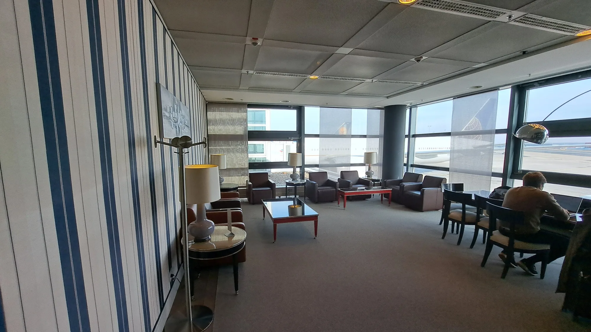Panoramalounge mit Sitzmöbeln und Blick auf Flugzeug