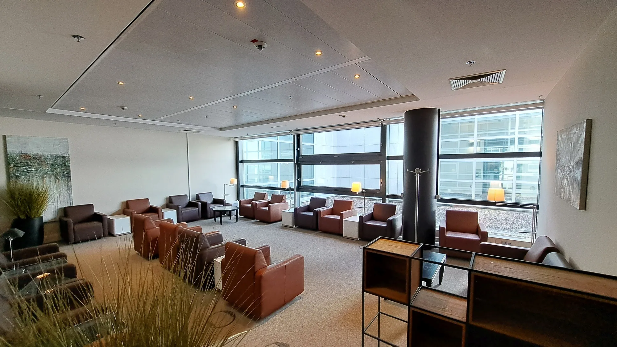 Lounge mit Sesseln und Fensterfronten