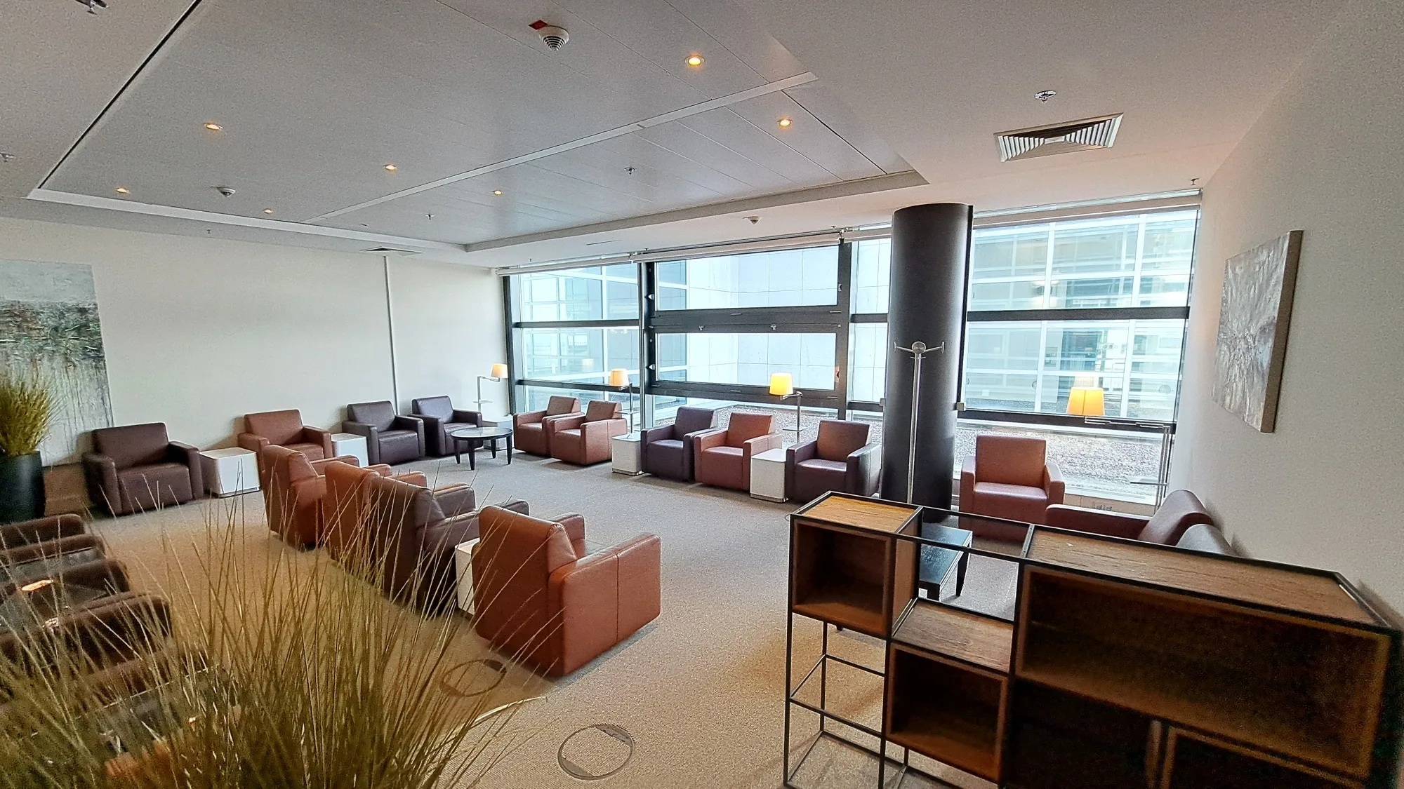 Lounge mit Sesseln und Fensterfronten
