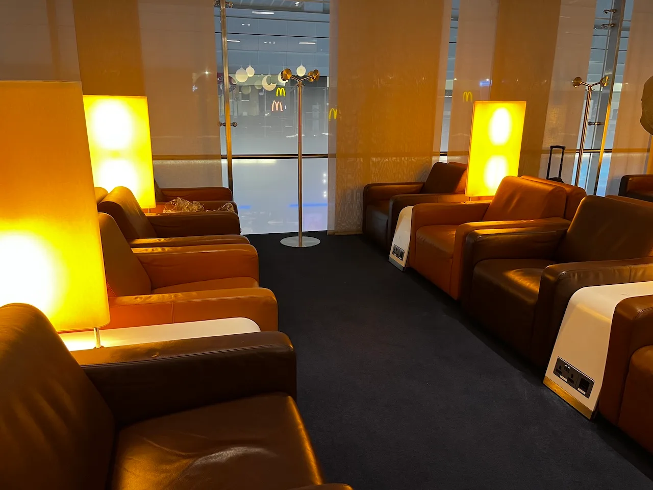 Lounge mit orangefarbenen Ledersesseln und gelben Beleuchtungselementen
