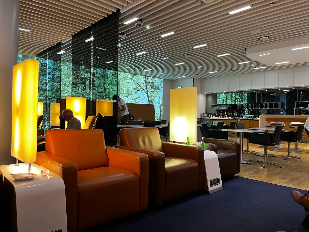 Lounge mit orangefarbenen Sesseln und Tischen