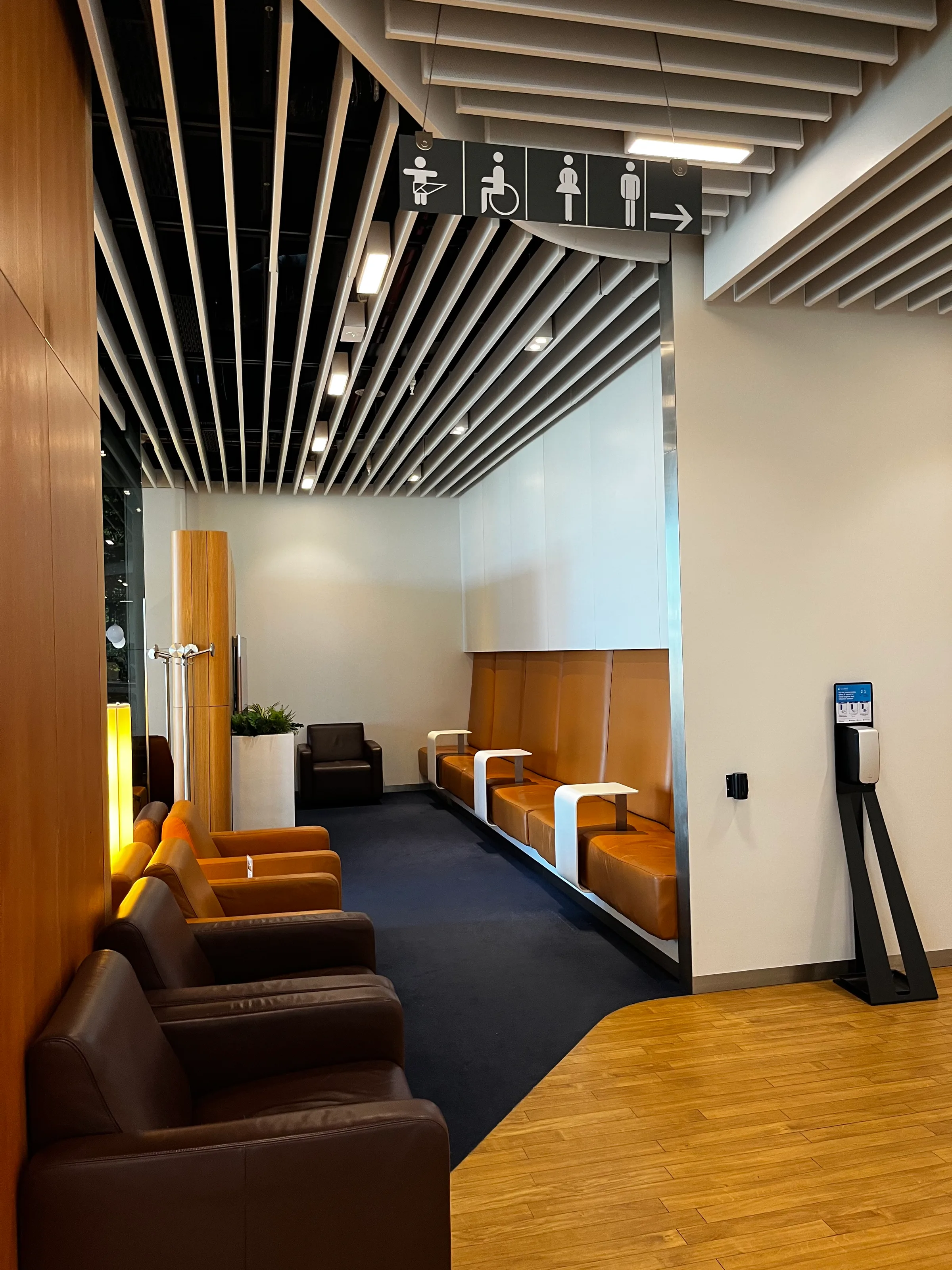 Lounge mit Sitzgelegenheiten und Toilettenzeichen