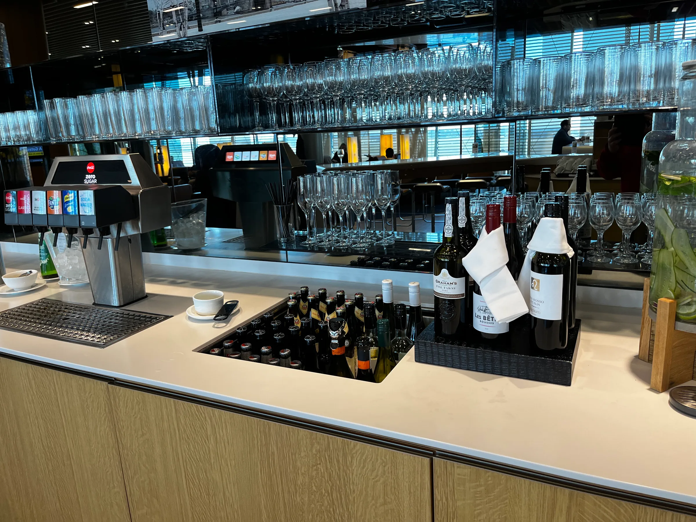 Bar mit Getränkeautomaten und Weinflaschen im Lufthansa Senator Lounge