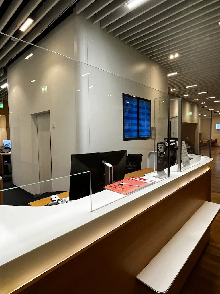 Rezeption mit Glaswänden und digitaler Anzeige im Lufthansa Senator Lounge München
