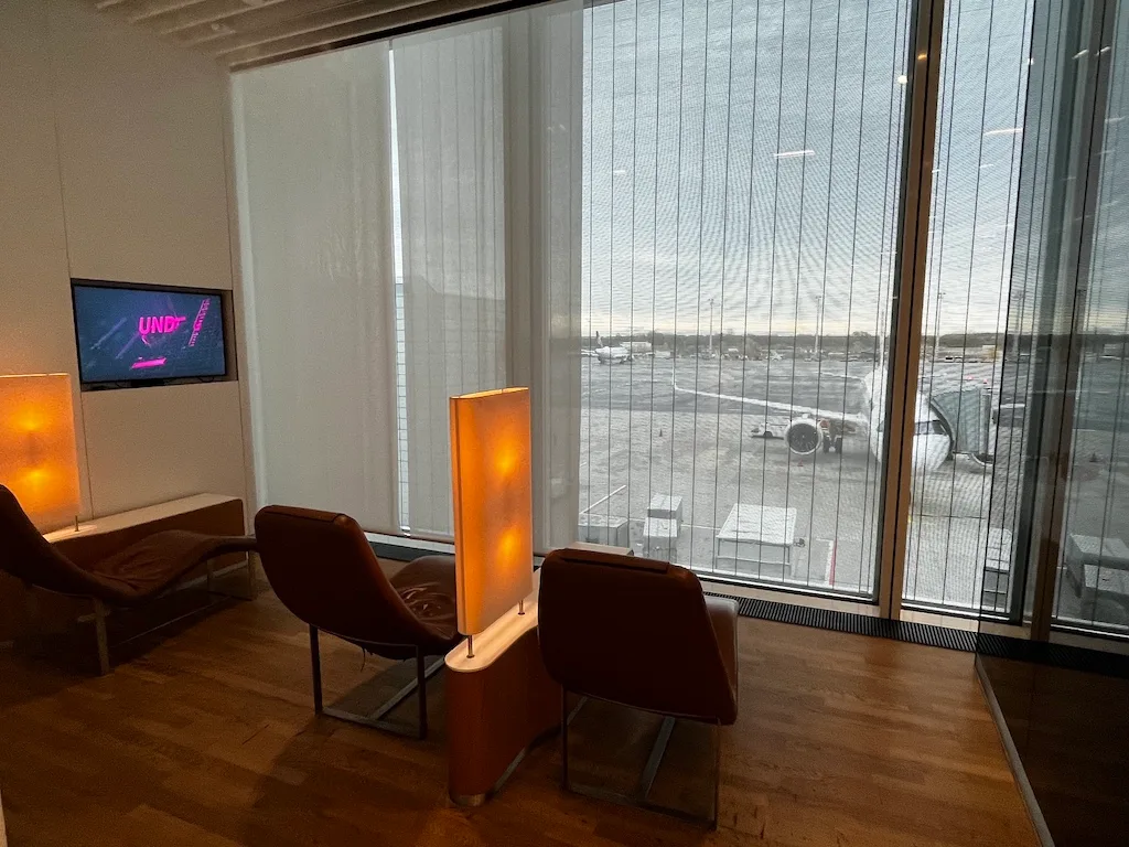 Lounge mit Sesseln und Fernseher im Flughafen