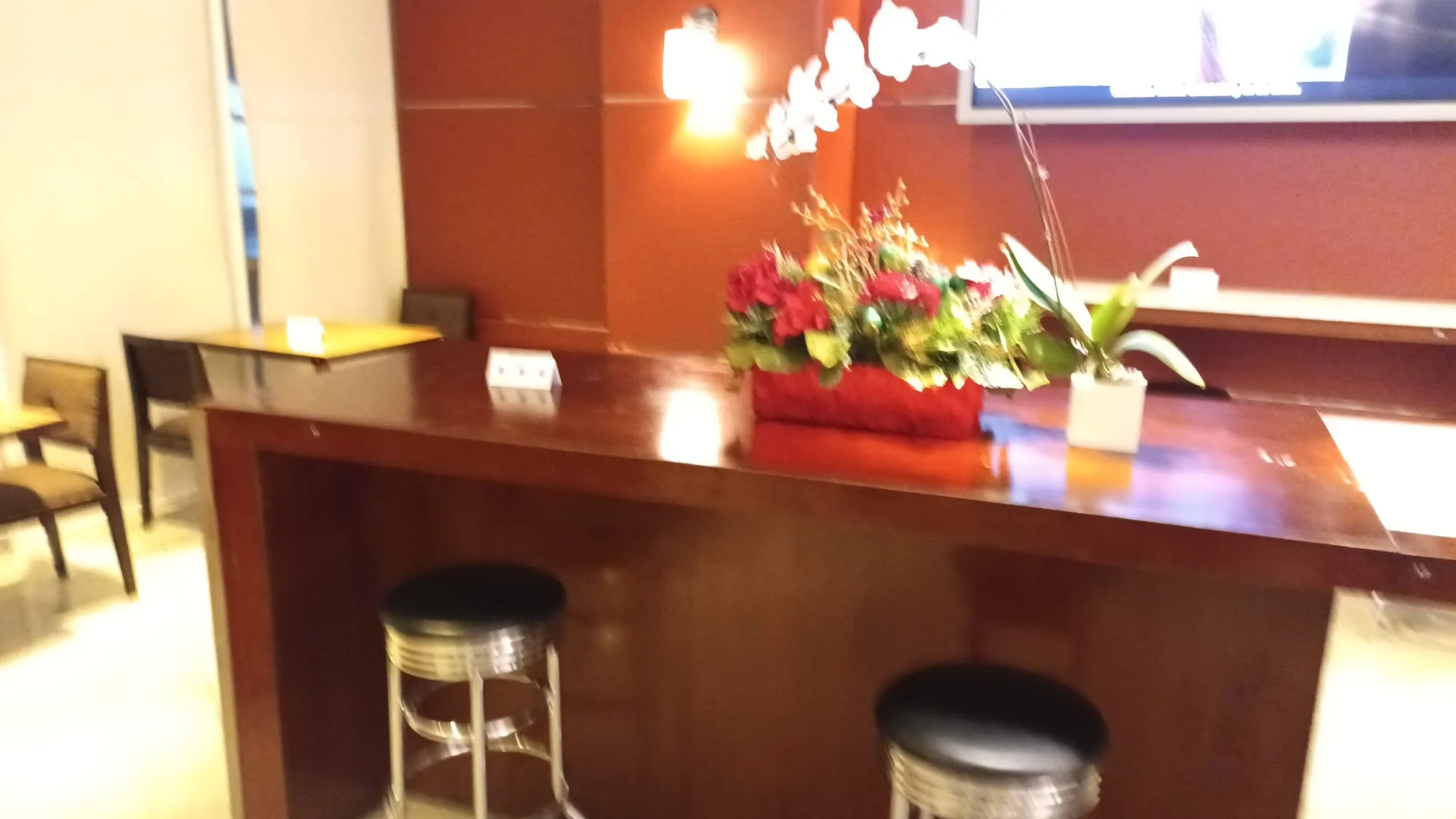 Lounge-Tresen mit Stühlen und Blumenarrangement