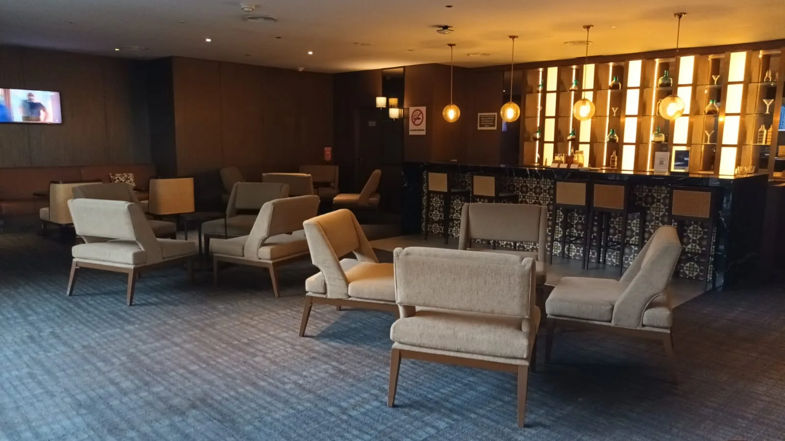 Lounge mit Sesseln und Bar im Hintergrund