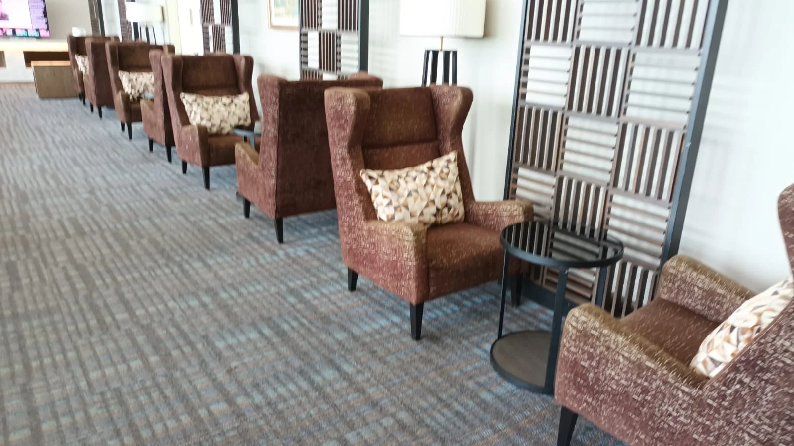 Reihen von Sesseln mit Kissen in einem Flughafensalon