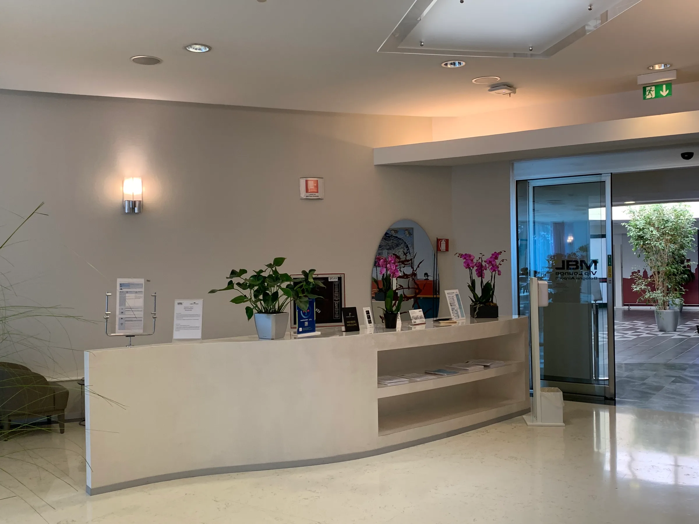 Rezeption mit Pflanzen und Blumen im Marconi Business Lounge am Flughafen Bologna