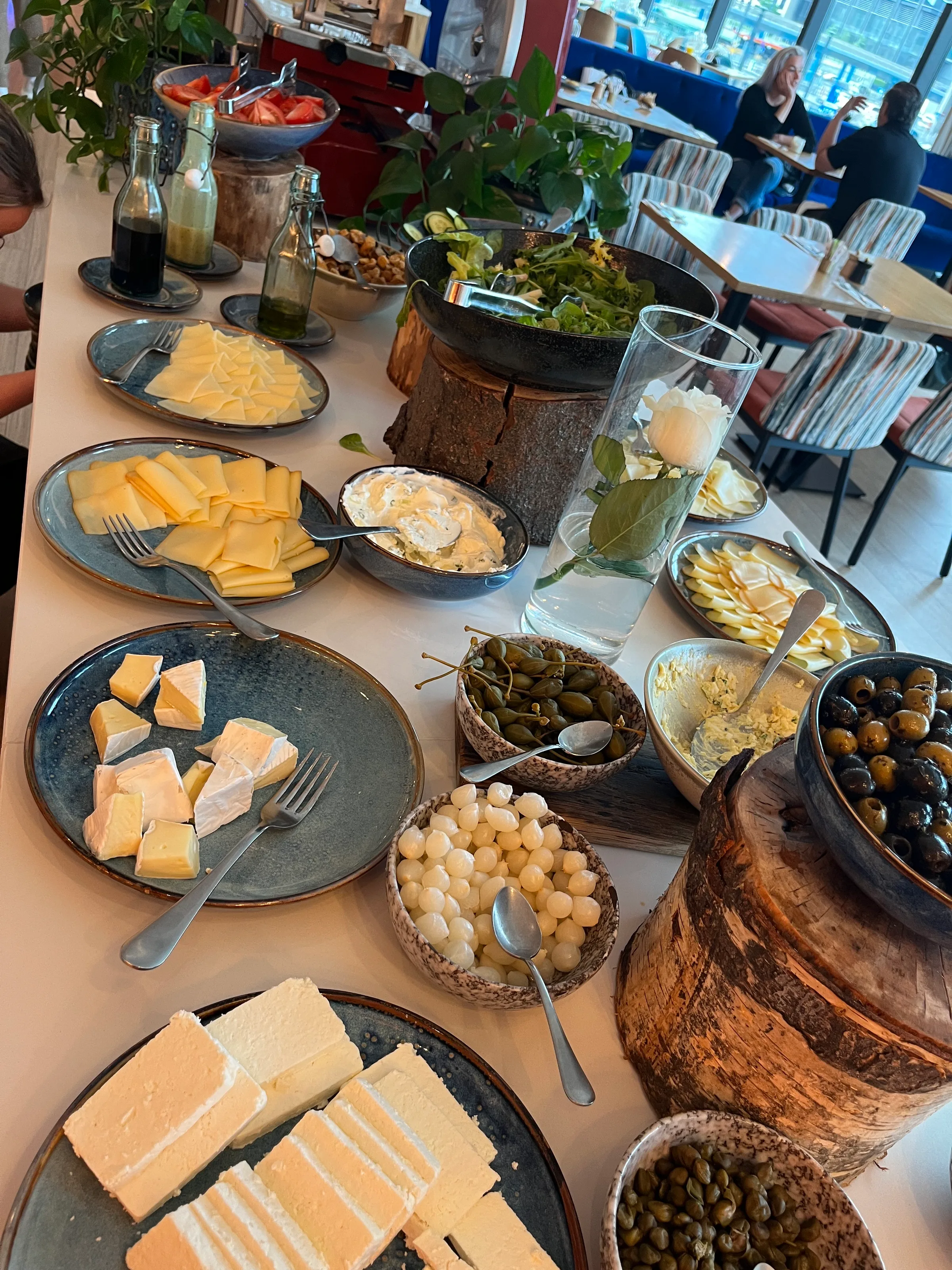 Frühstückstisch mit Käse, Salat und Oliven