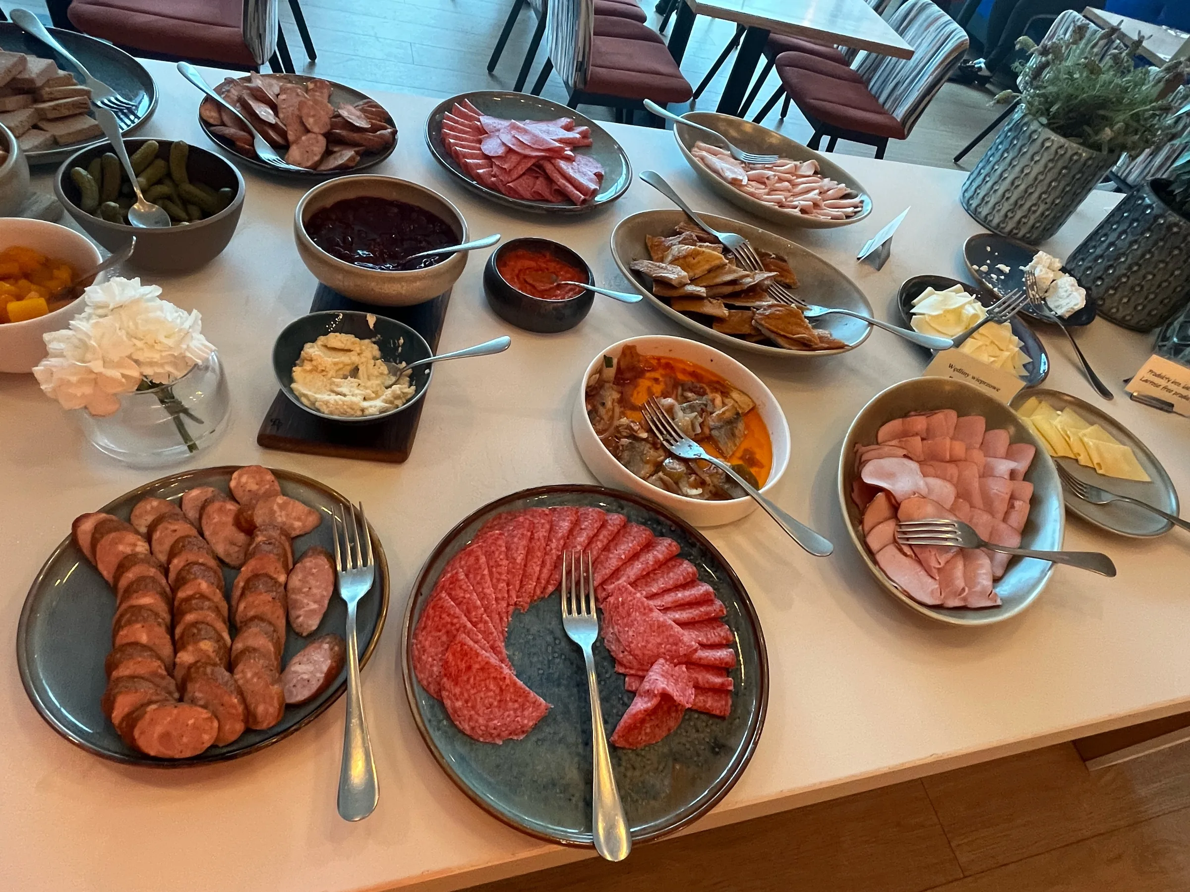 Frühstückstisch mit verschiedenen Wurstsorten und Beilagen