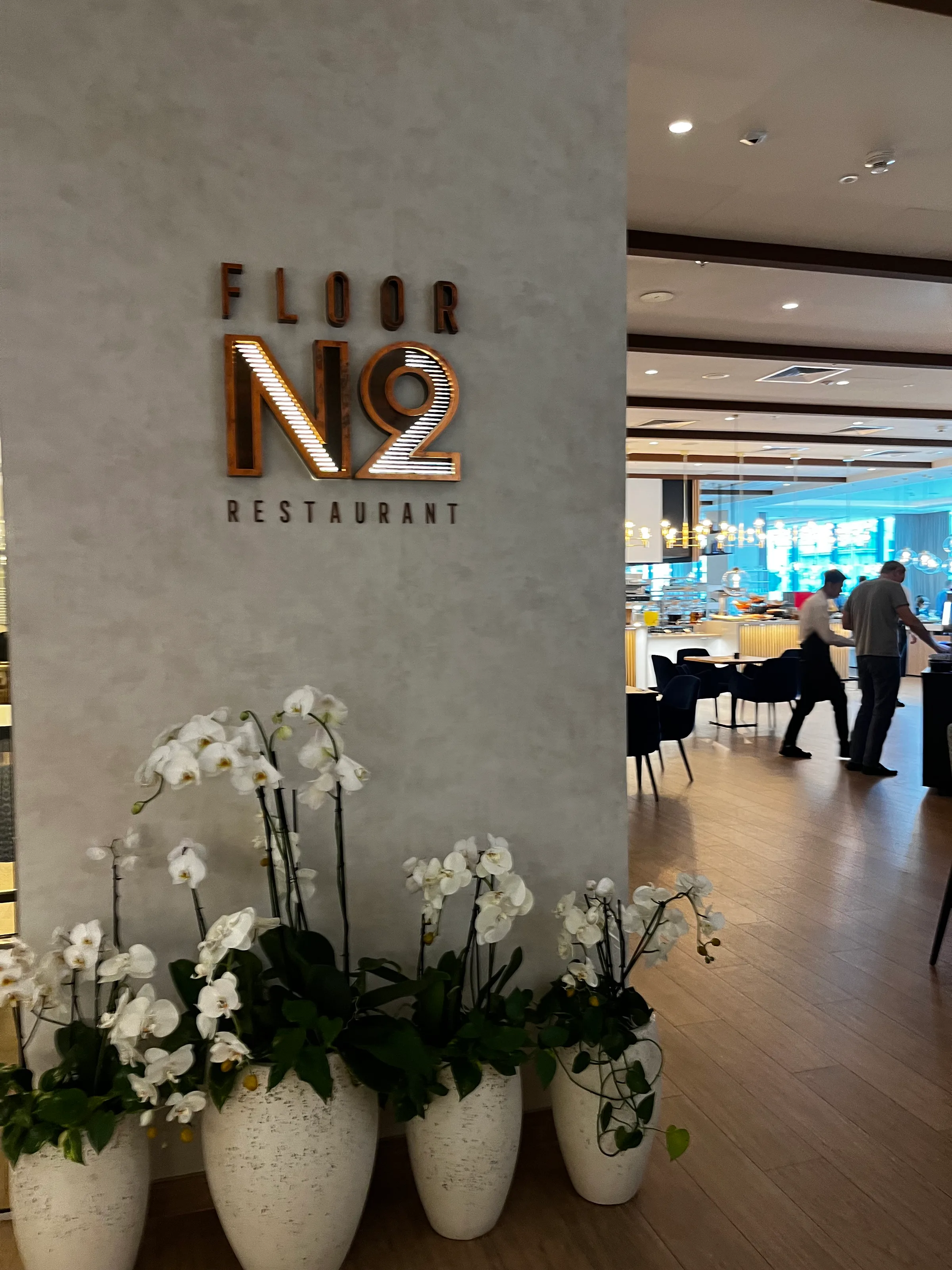 Eingang zum Restaurant Floor No. 2 mit Orchideen im Vordergrund