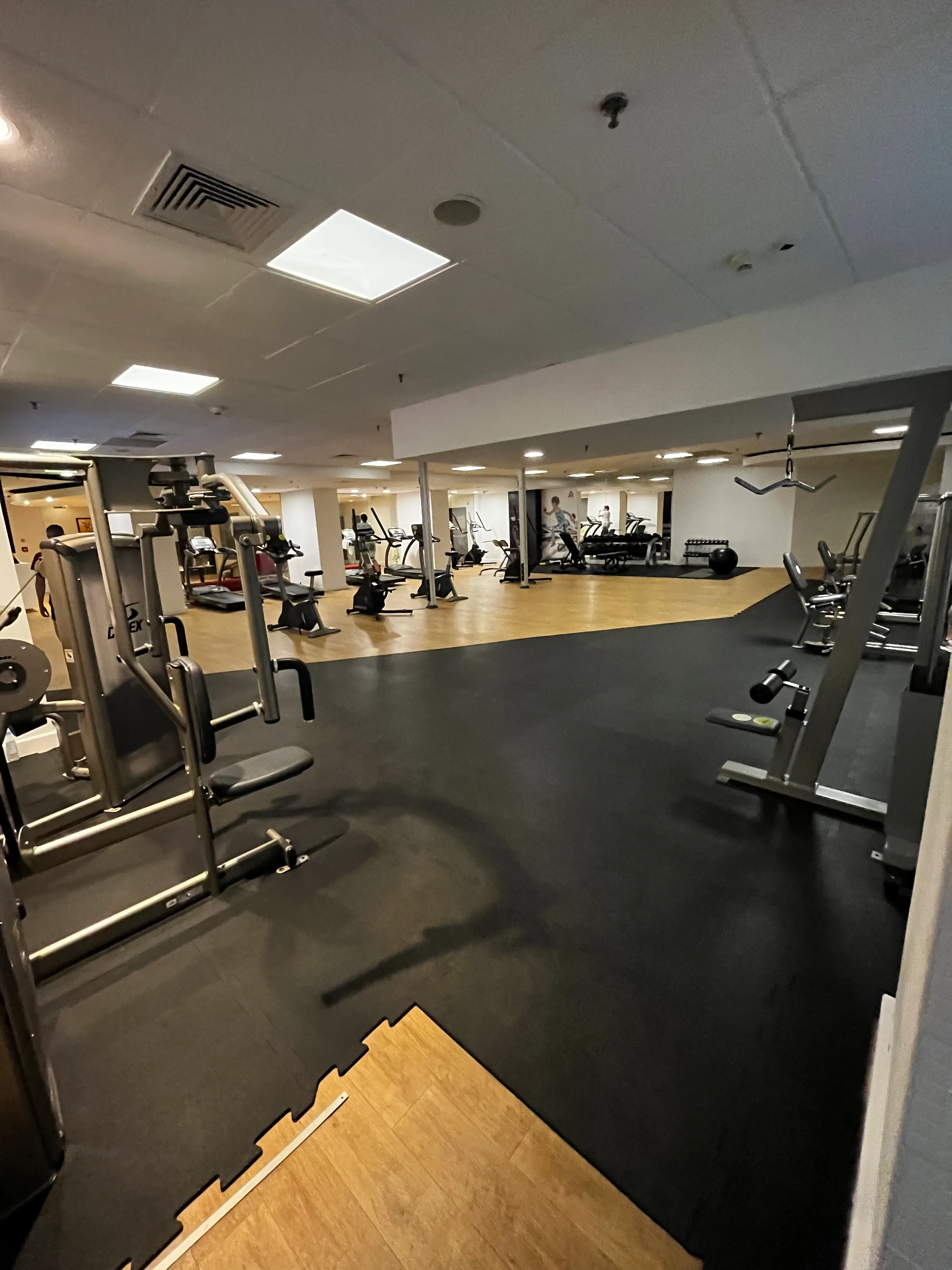 Gymnastikraum mit Fitnessgeräten und schwarzer Bodenbelag