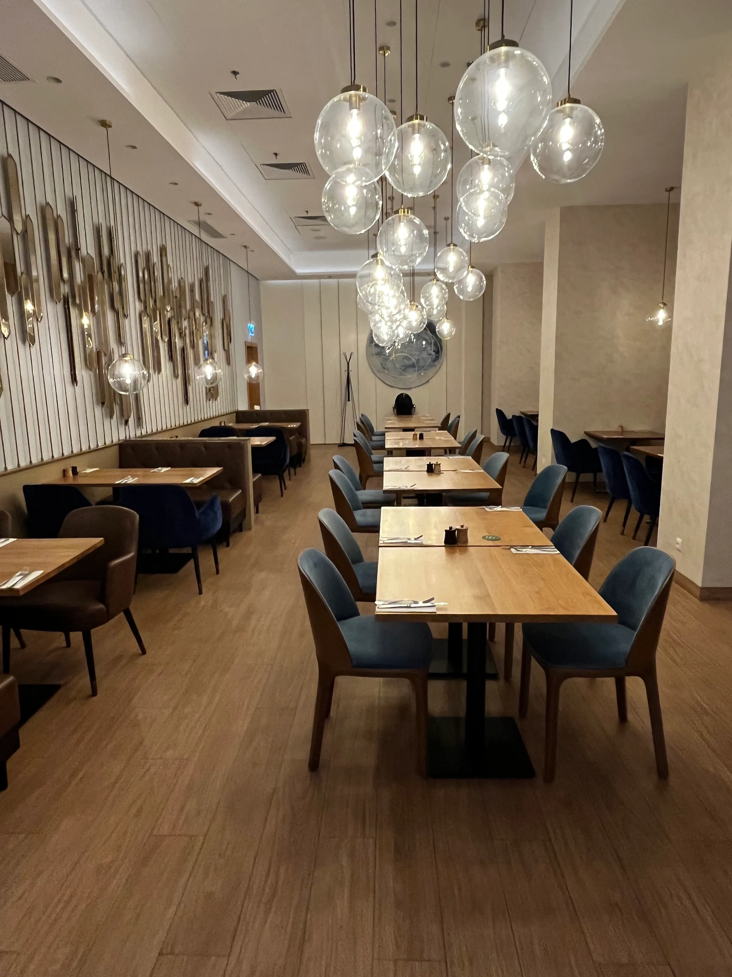 Essbereich im Restaurant mit Holztischen und blauen Stühlen