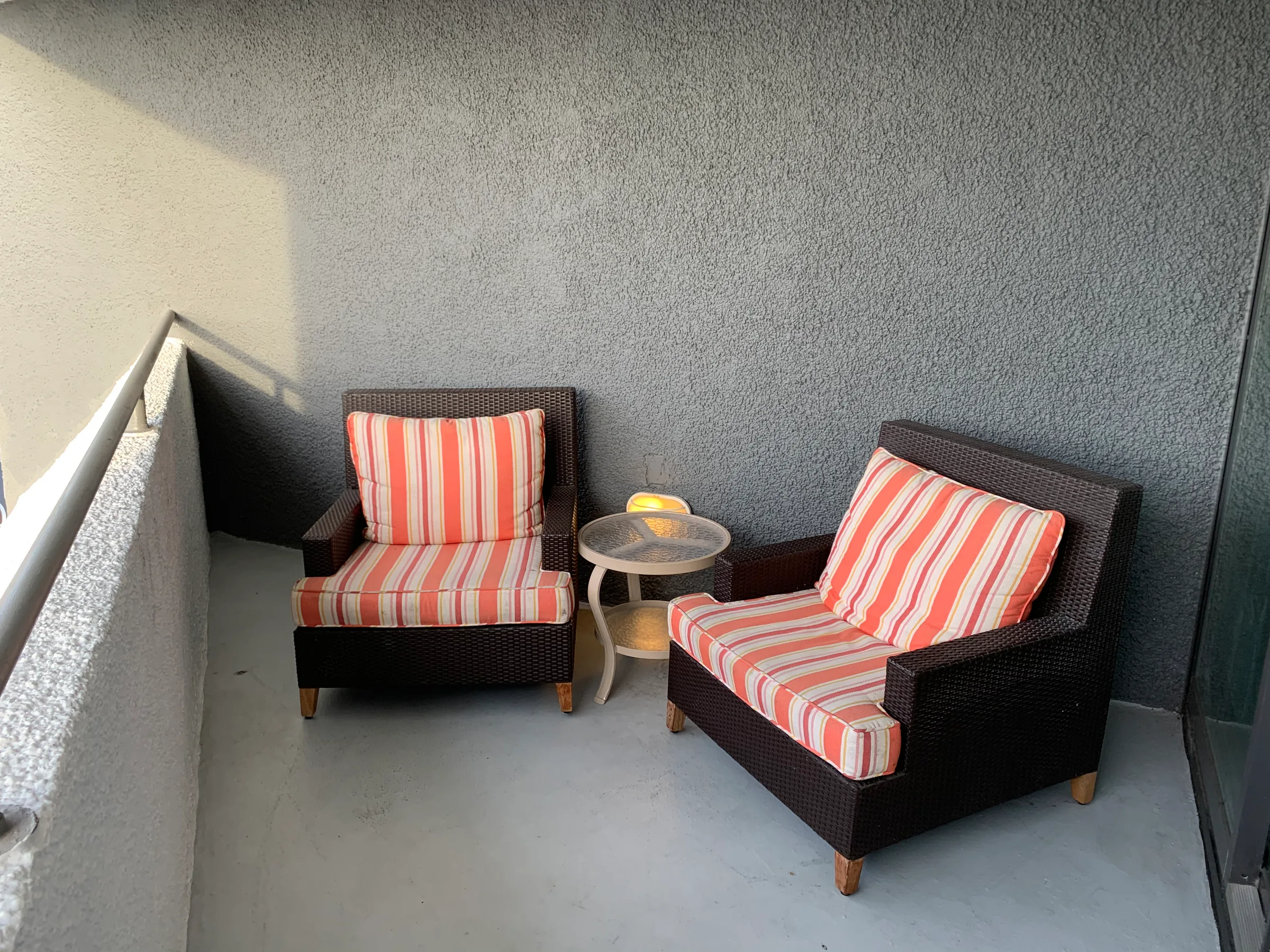 Terrasse mit zwei gestreiften Sesseln und einem kleinen Tisch