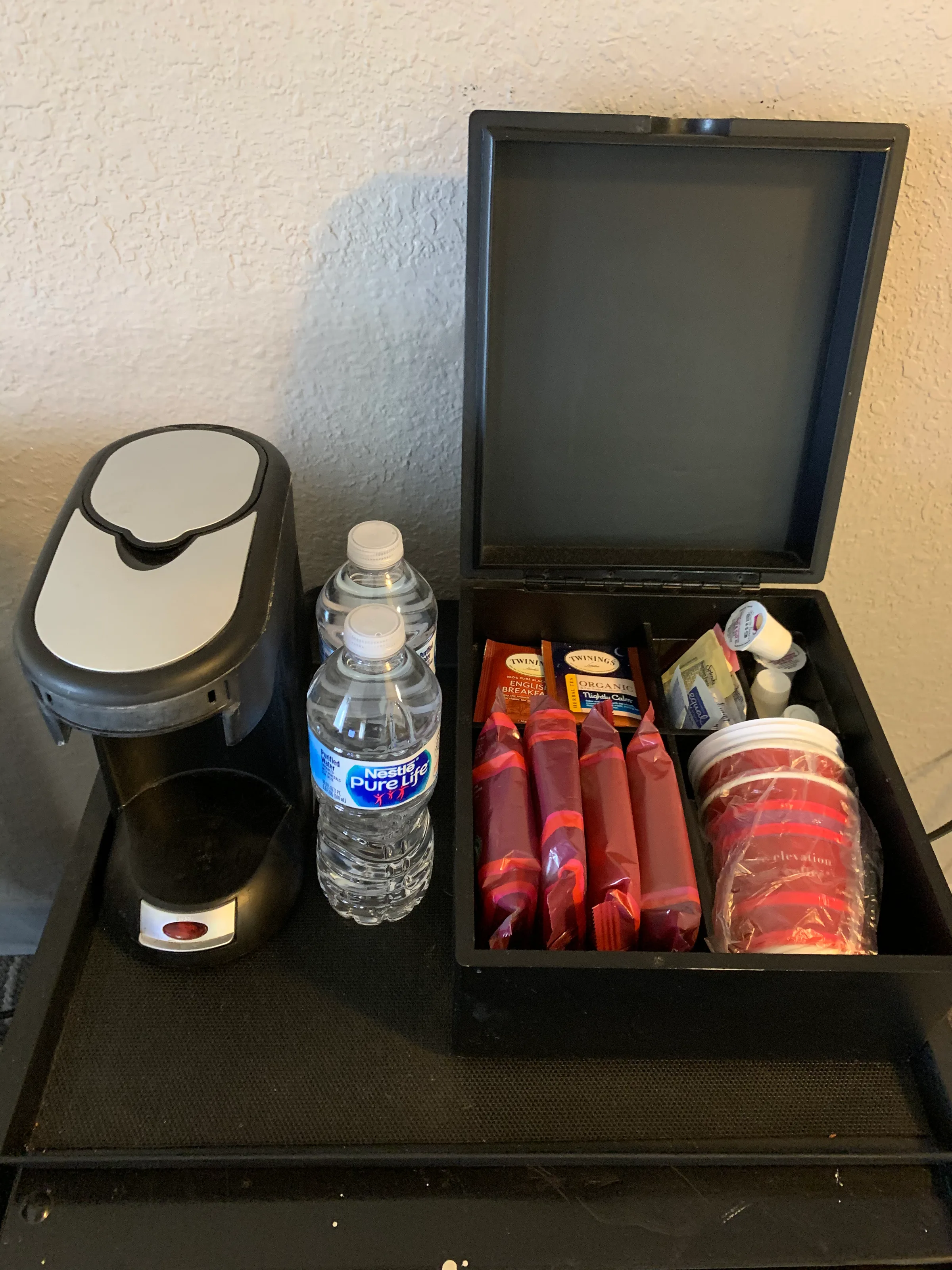 Kaffeemaschine, Wasserflasche und Kofferraum mit Getränken und Snacks