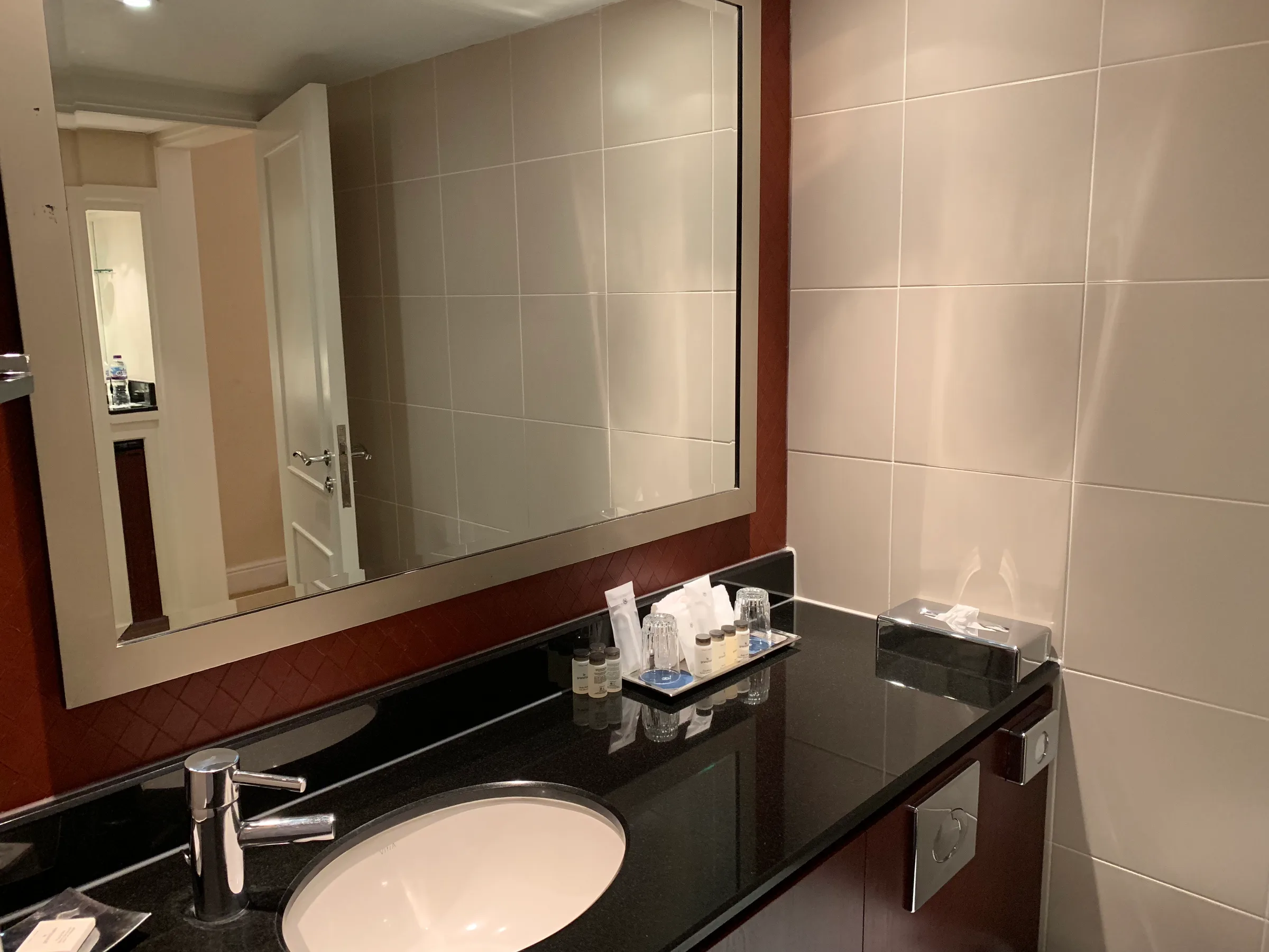 Hotelbadezimmer mit Waschbecken, Spiegel und Kosmetikset