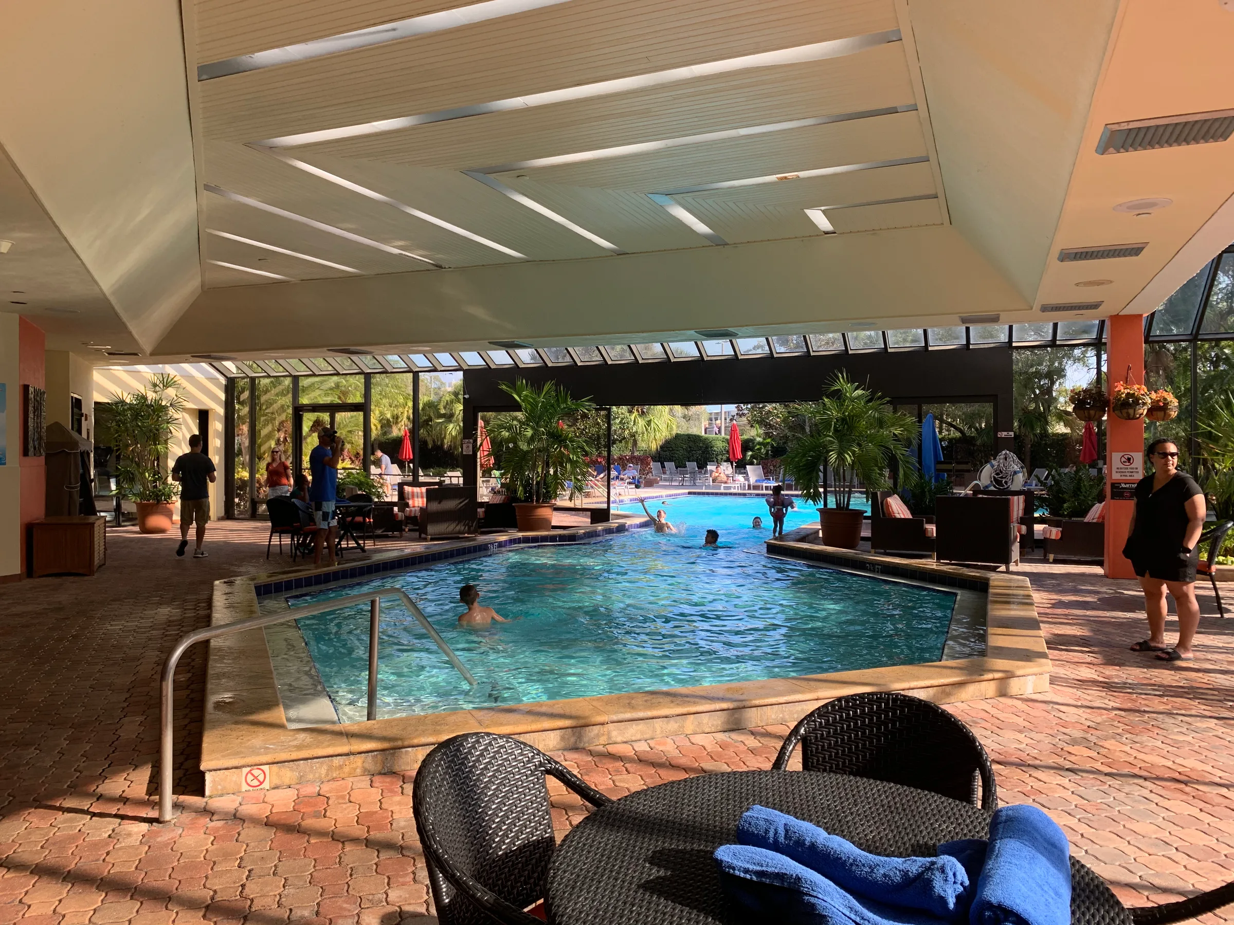 Indoor Pool mit Menschen und Sonnenschirmen im Hintergrund