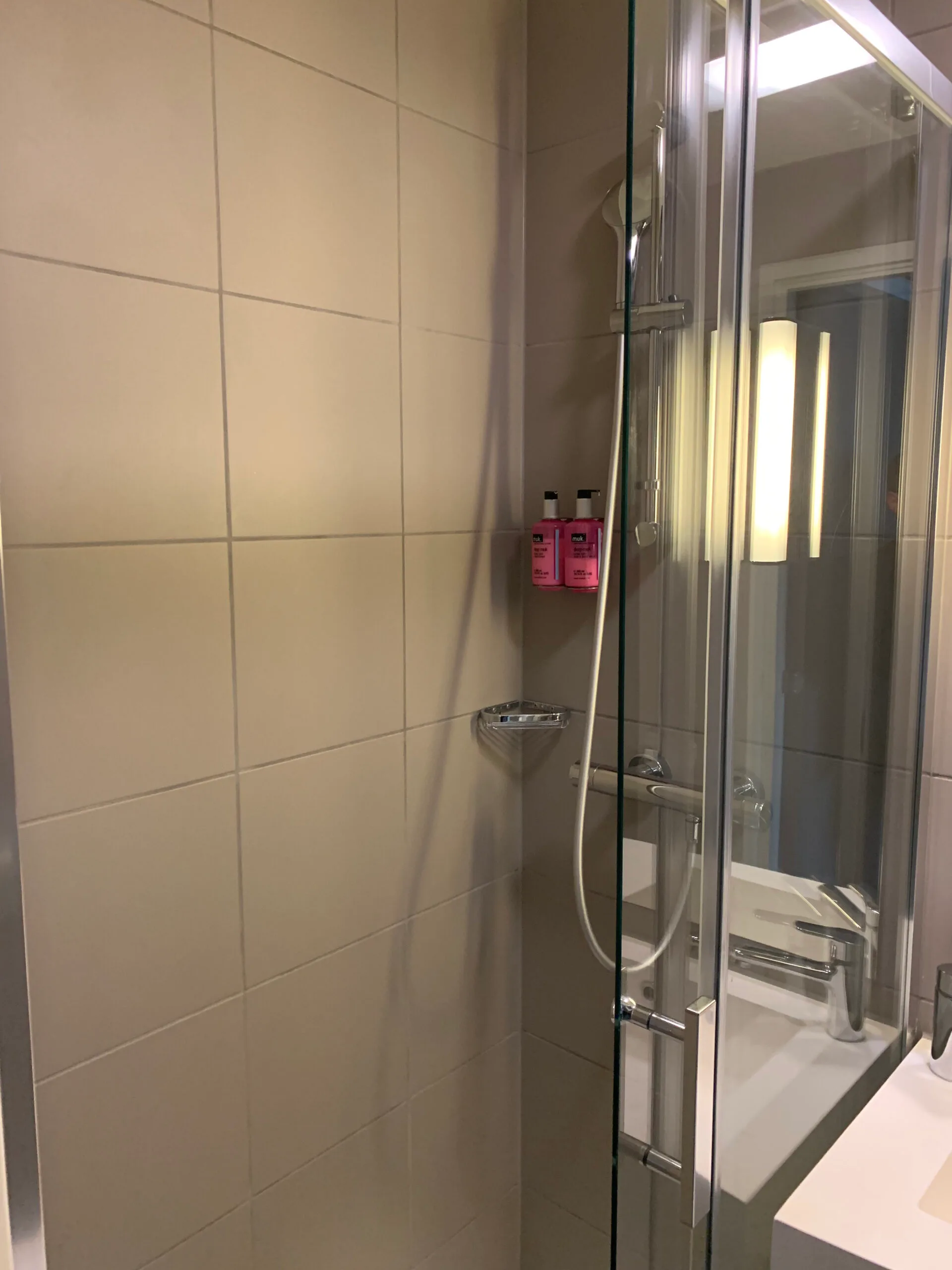 Duschabtrennung mit Flüssigseifenbehältern an der Wand
