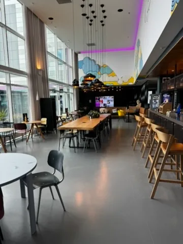 Lobbybereich eines Hotels mit Holztischen und Stühlen