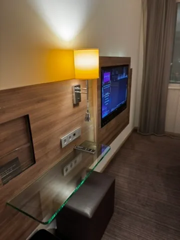 Hotelzimmer mit Flachbildfernseher und Wandlampe