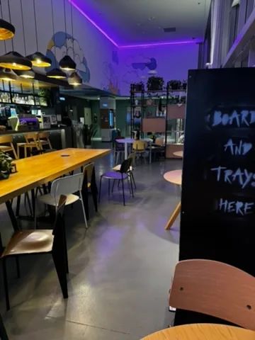 Loungebereich mit Holztischen und Stühlen in einem Flughafen-Hotel