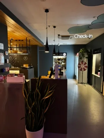 Rezeption eines Hotels mit Pflanze und Check-in-Schild