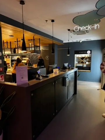 Rezeption eines Hotels mit Check-in-Schild und Mitarbeiter