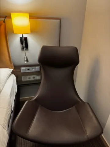 Hotelzimmer mit Sessel und Nachttischlampe