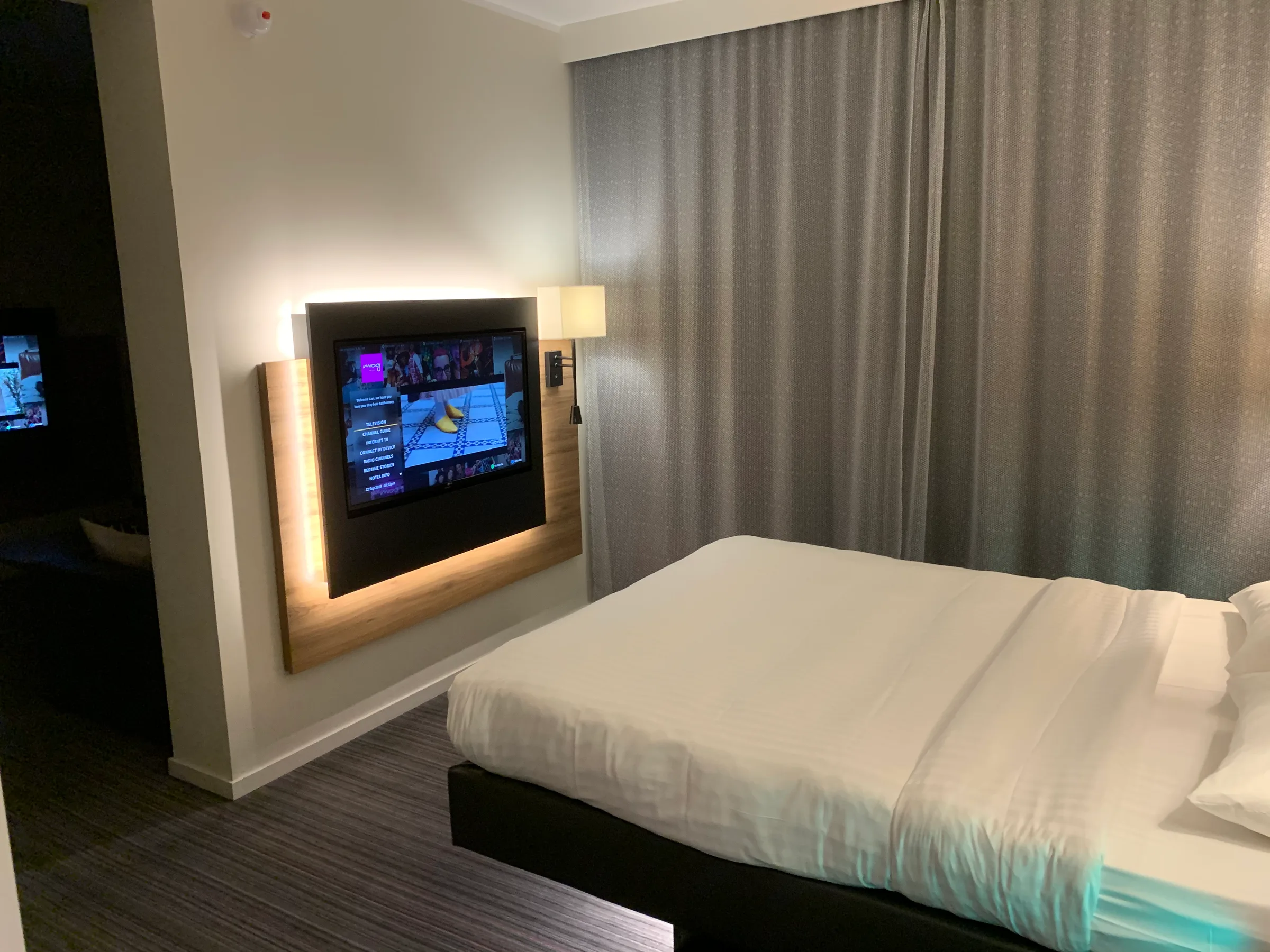 Hotelzimmer mit Doppelbett und Fernseher an der Wand