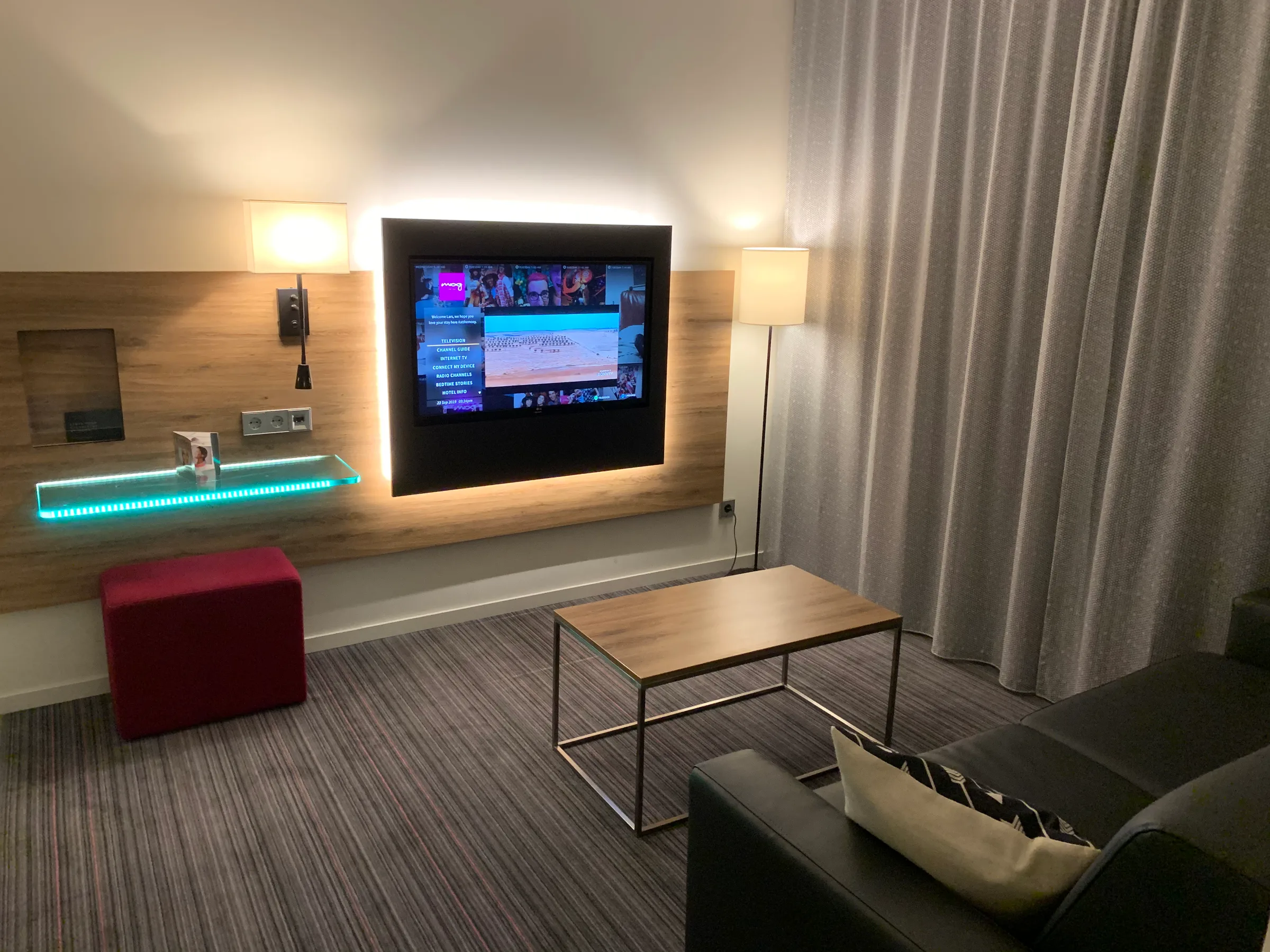 Hotelzimmer mit Fernseher und Couch im modernen Design