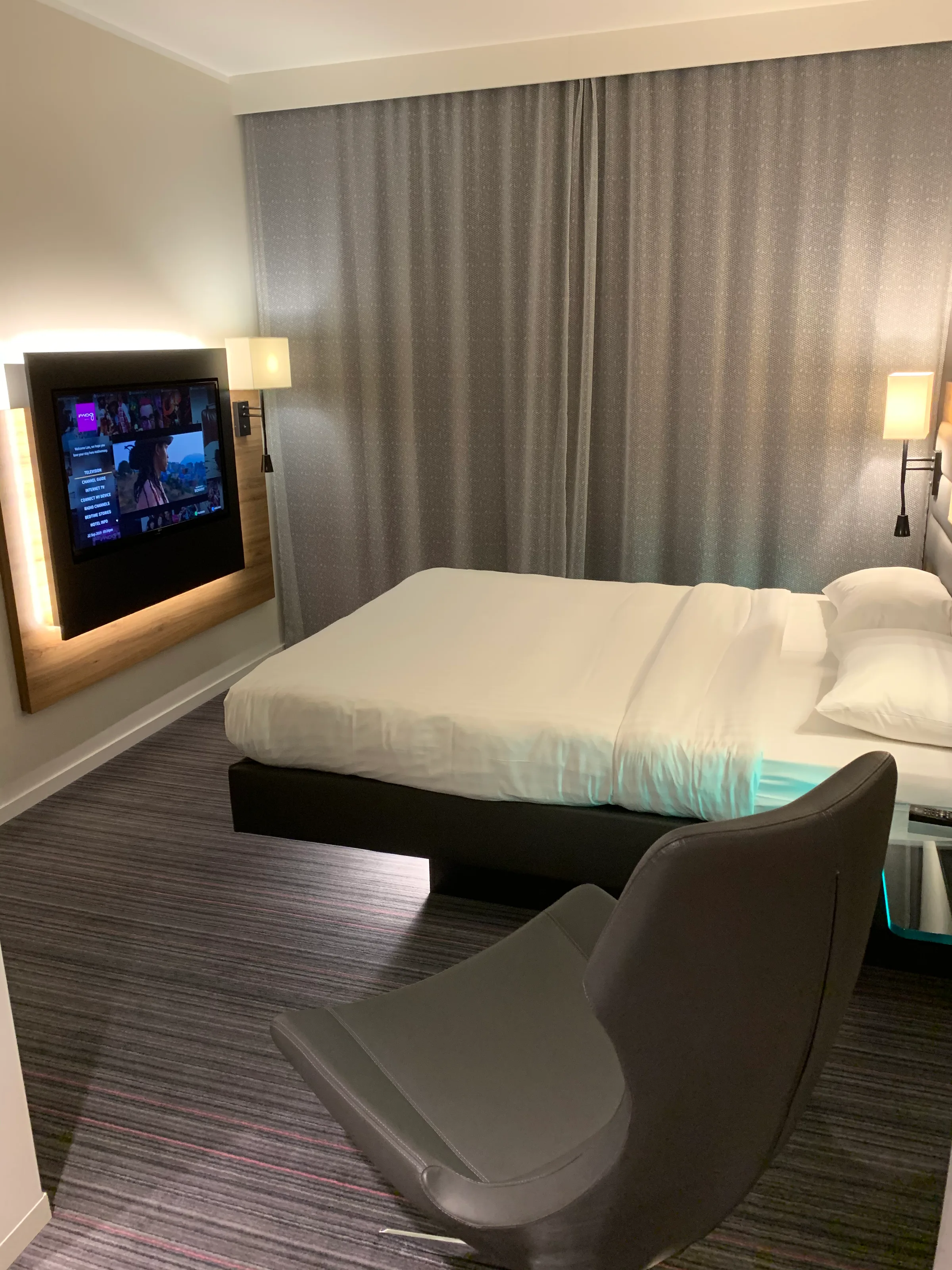 Hotelzimmer mit Doppelbett und Fernseher an der Wand