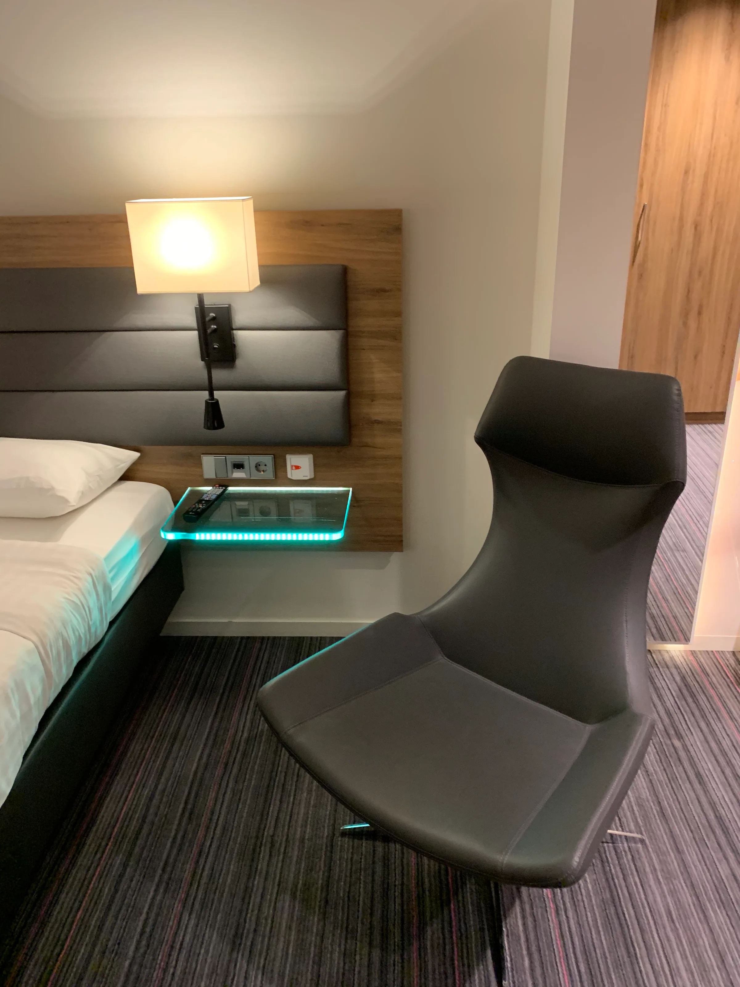 Hotelzimmer mit Doppelbett und moderner Sitzbank