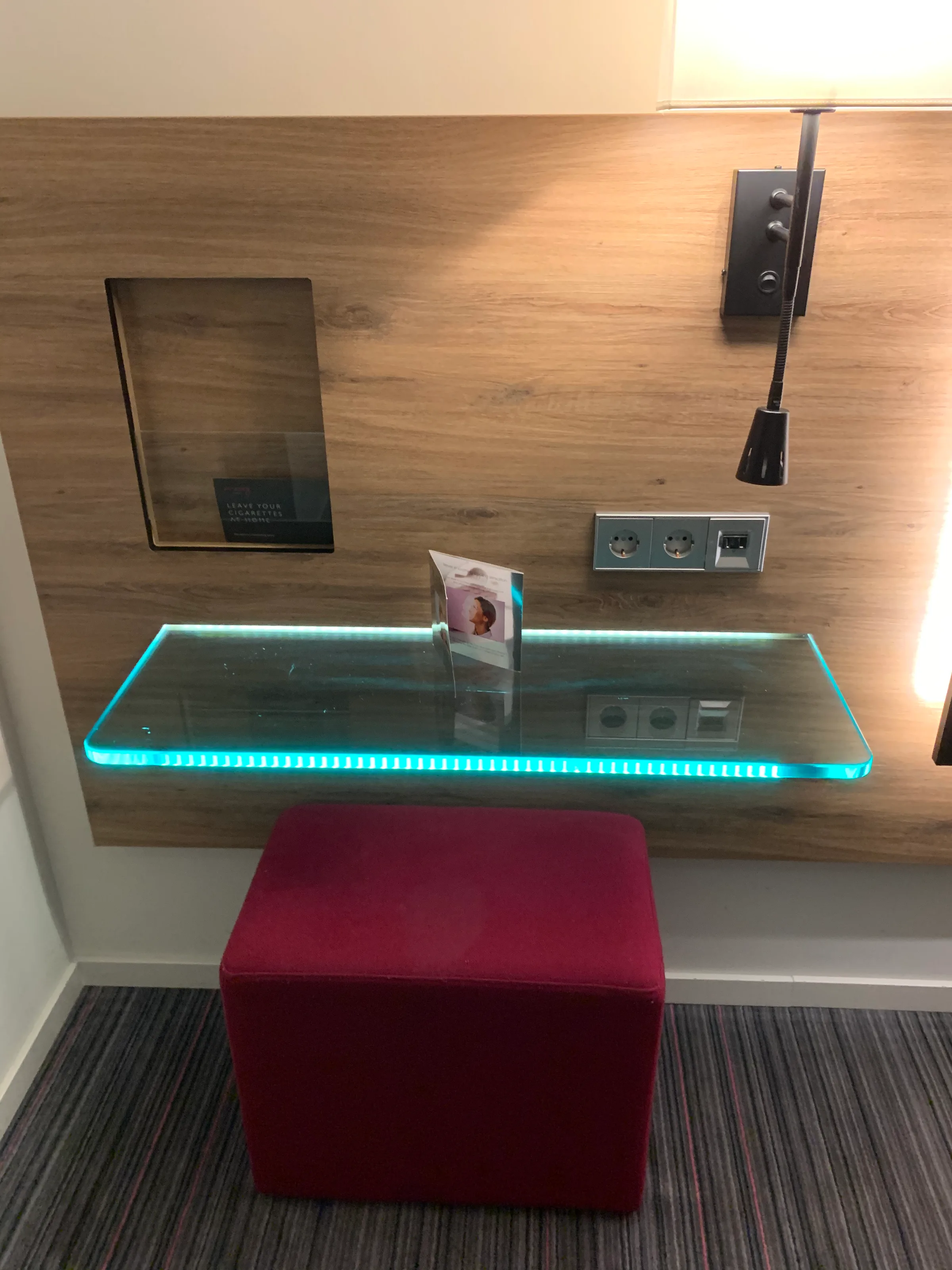 Glasplatte mit blauem LED-Licht und Sitzkissen im Hotelzimmer