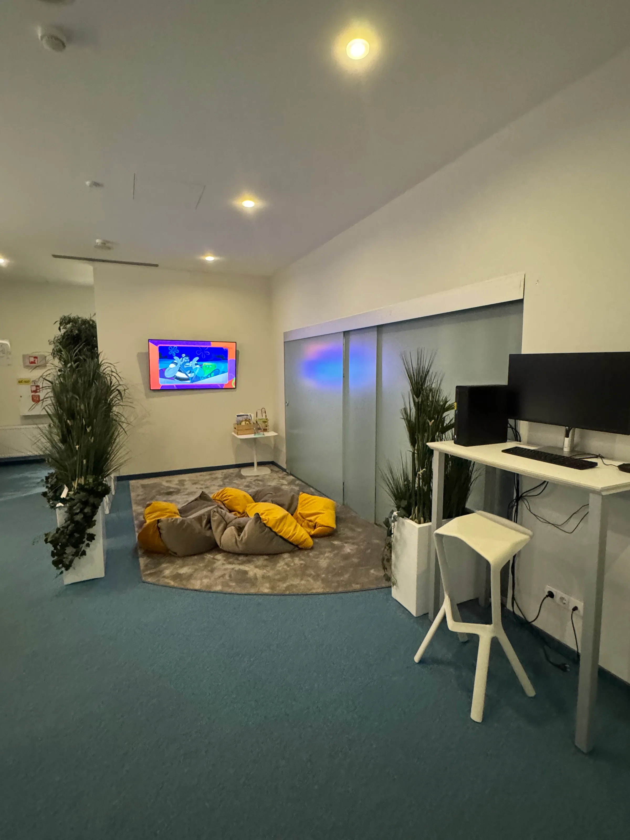 Business Lounge mit Sitzkissen und Fernseher an der Wand