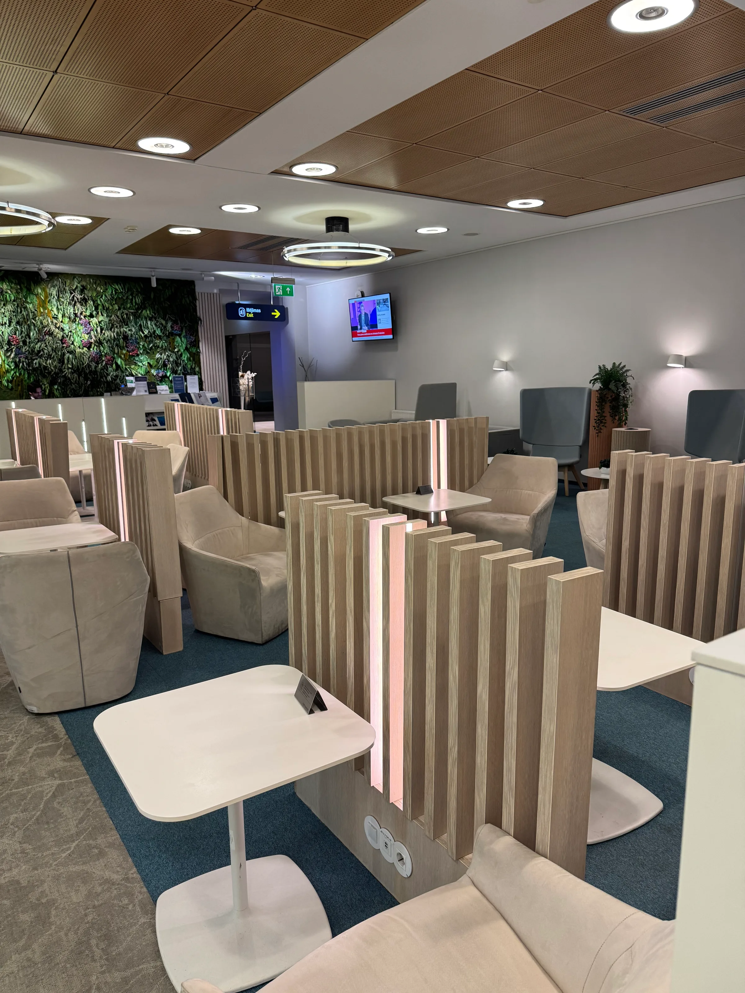 Business Lounge mit Sesseln und Tischen in neutralen Farben