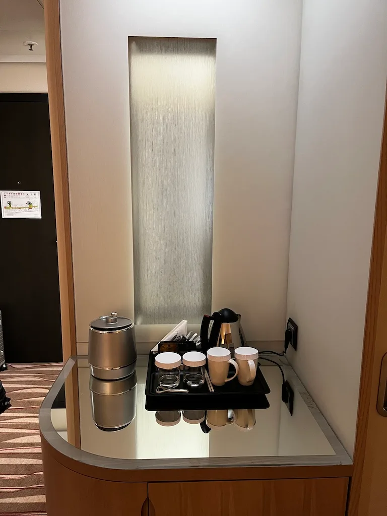 Hotelzimmer mit Kaffeemaschine und Tassen auf Serviertablett