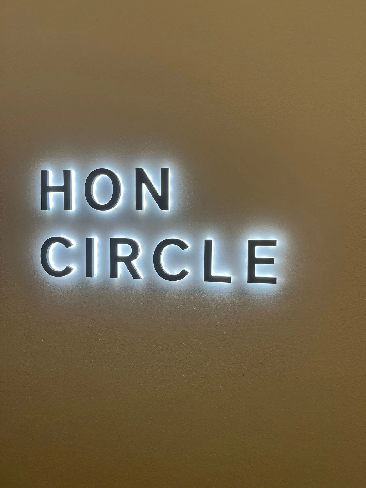 Lounge-Schild mit Aufschrift 'HON Circle' an der Wand