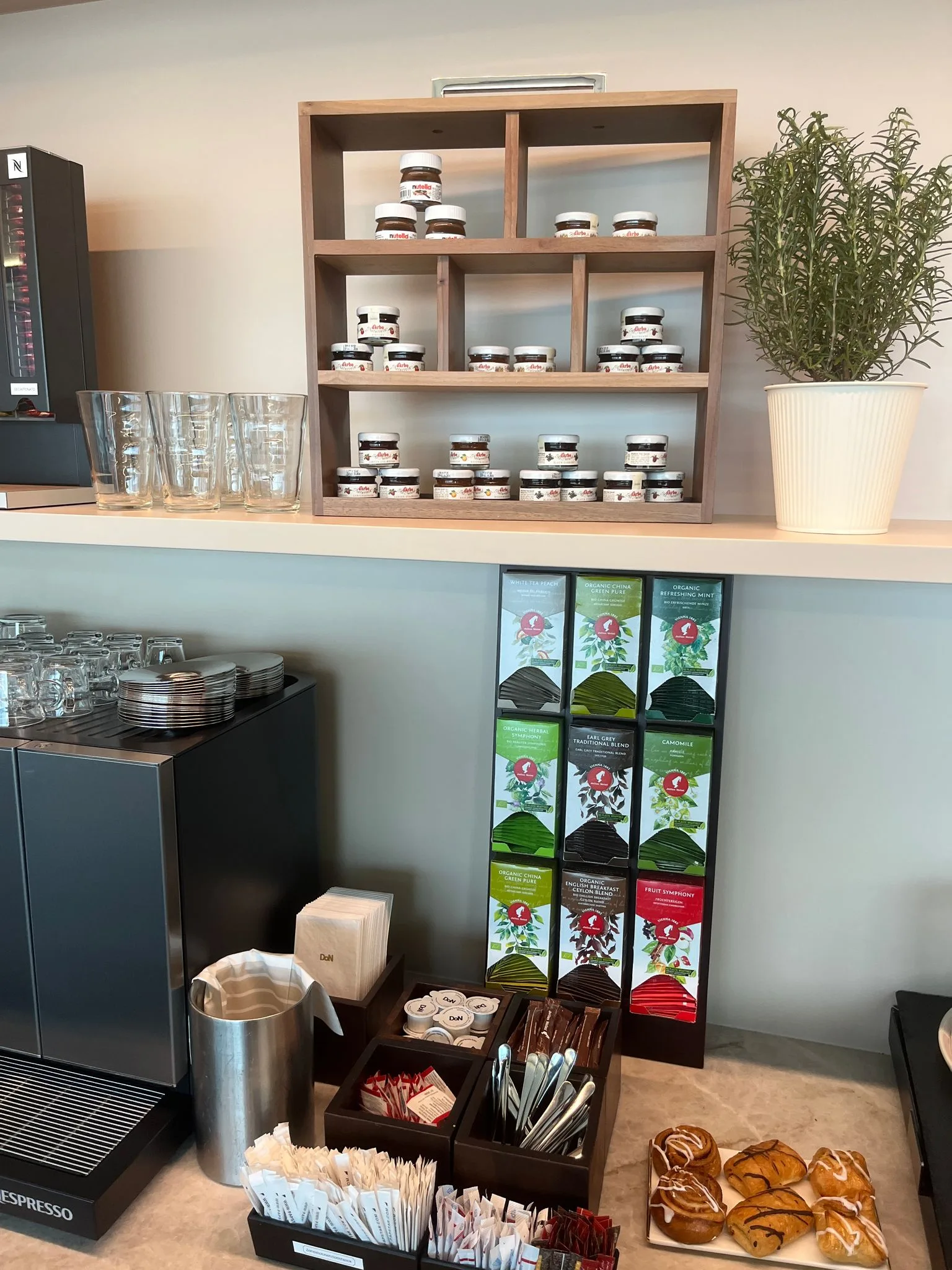 Kaffeebar mit Gläsern, Teebeuteln und Gebäck