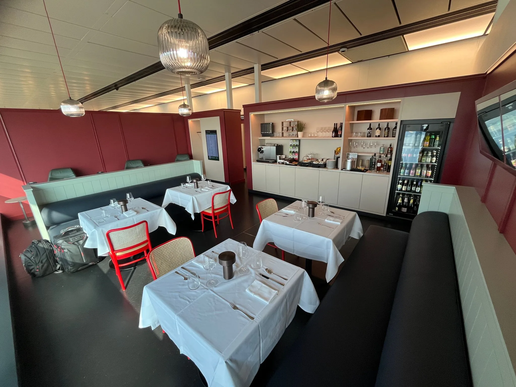 Lounge mit Tischen und Sitzgelegenheiten in roten und schwarzen Farbtönen