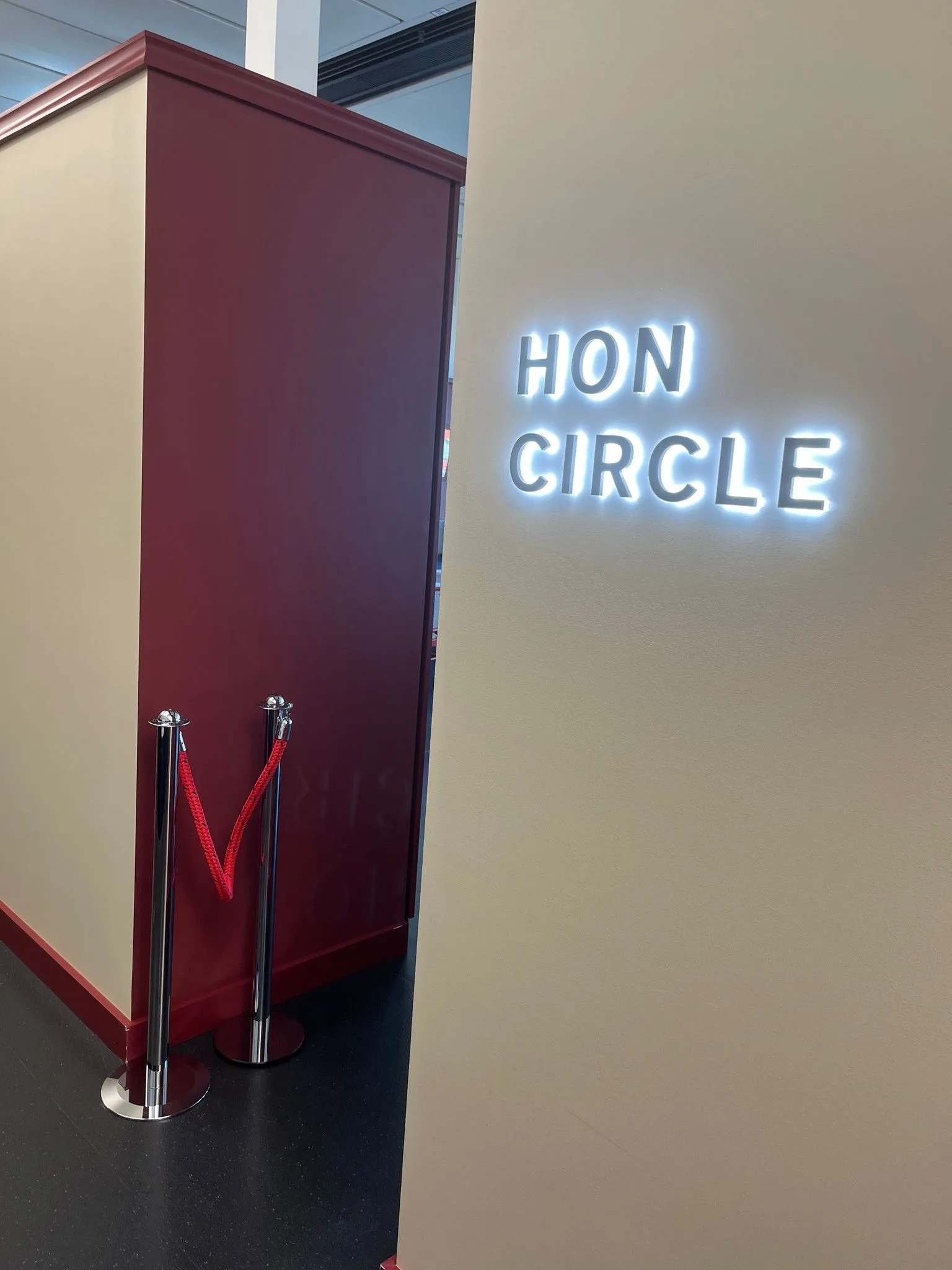 HON Circle-Schild an Wand mit rotem Vorhang